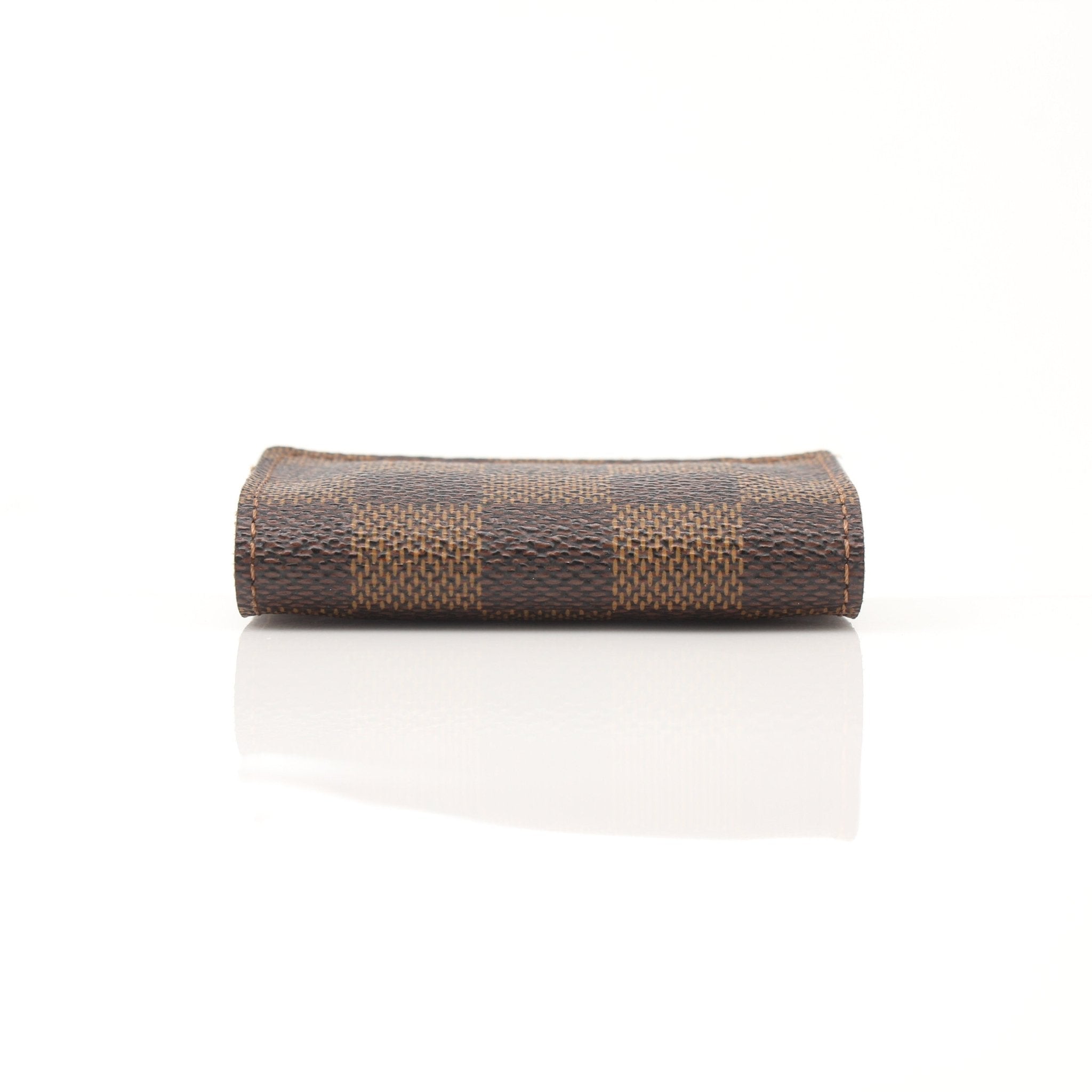 Louis Vuitton Damier Ebene key holder pouch with gold-tone hardware, featuring the signature checkered pattern and compact design.