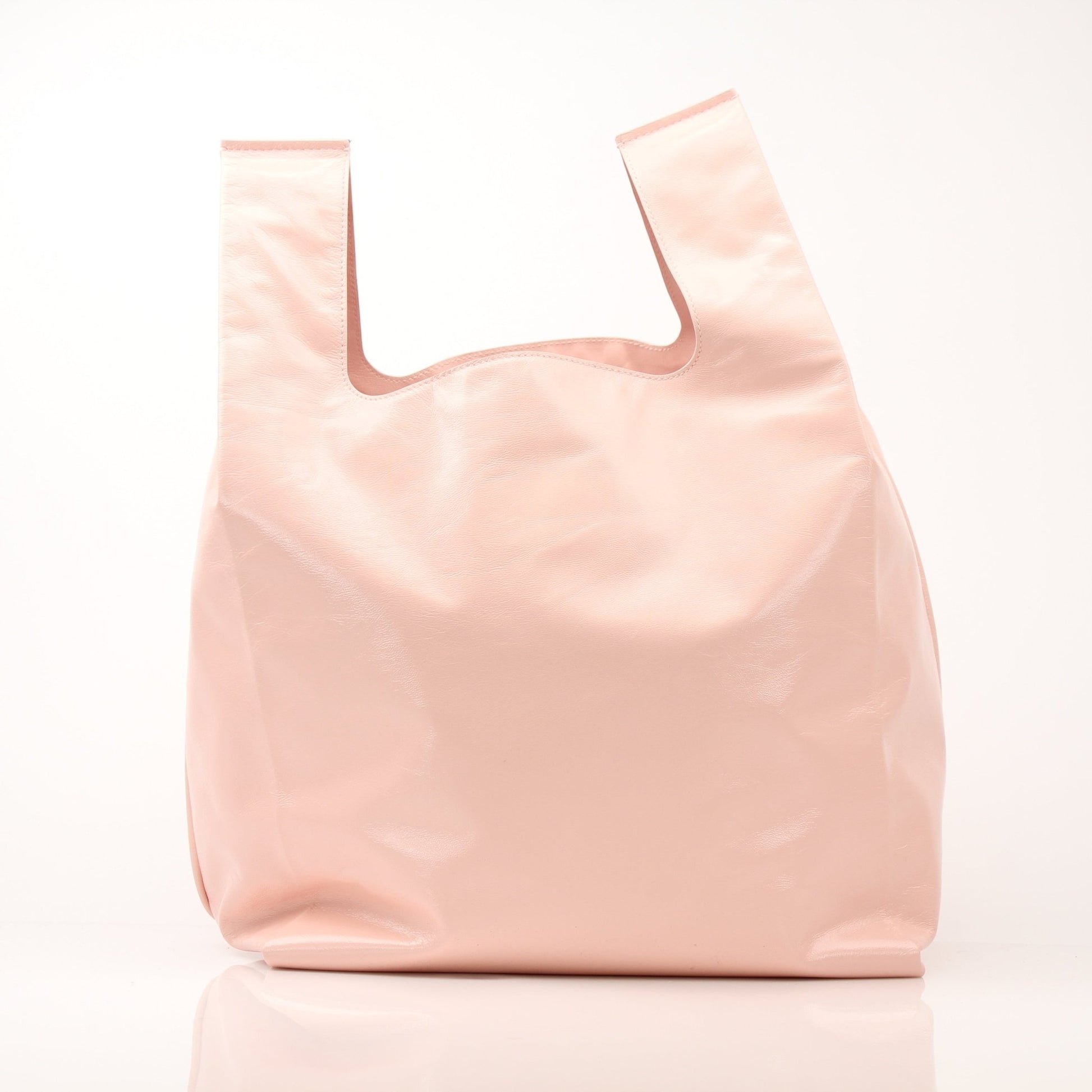 Pink Bottega Veneta Super Mercato Mermaid tote bag with woven leather design, carried by a hand, showcasing its spacious interior.