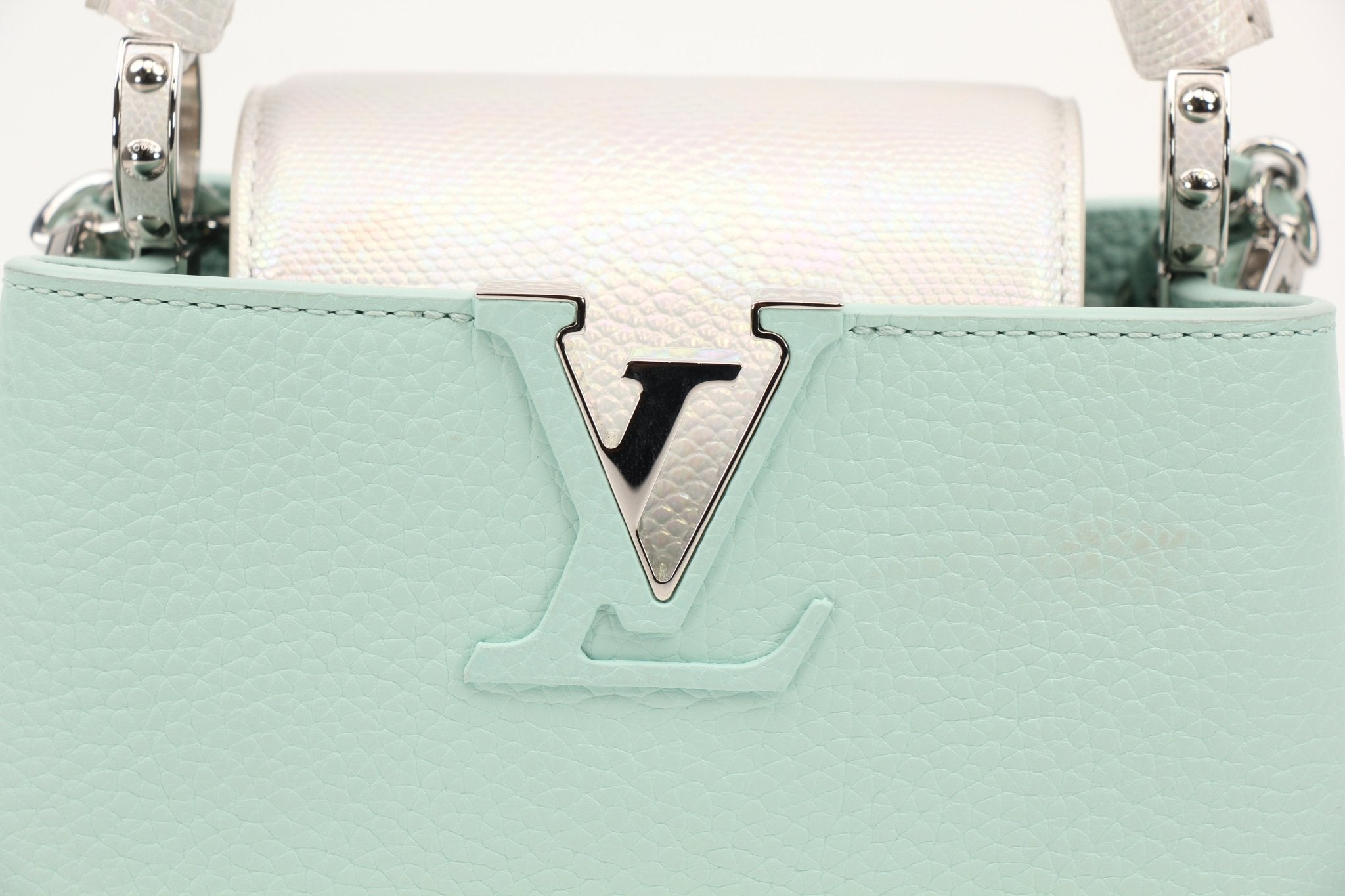 Louis Vuitton Capucines handbag with leather exterior and gold hardware, displayed on a neutral background.