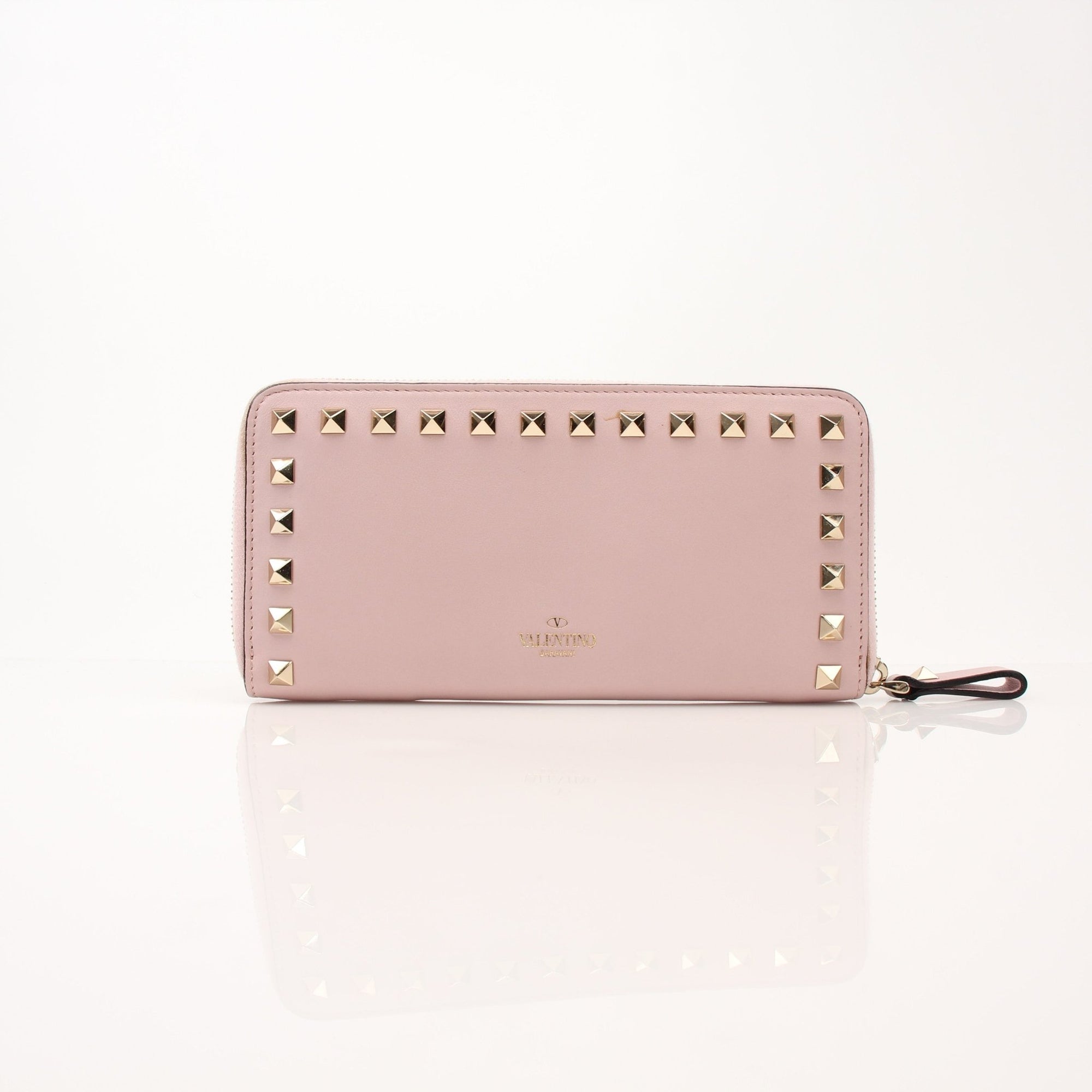 Valentino Pink Rockstud zip-around wallet with gold-tone hardware, featuring multiple card slots and a sleek, stylish design.