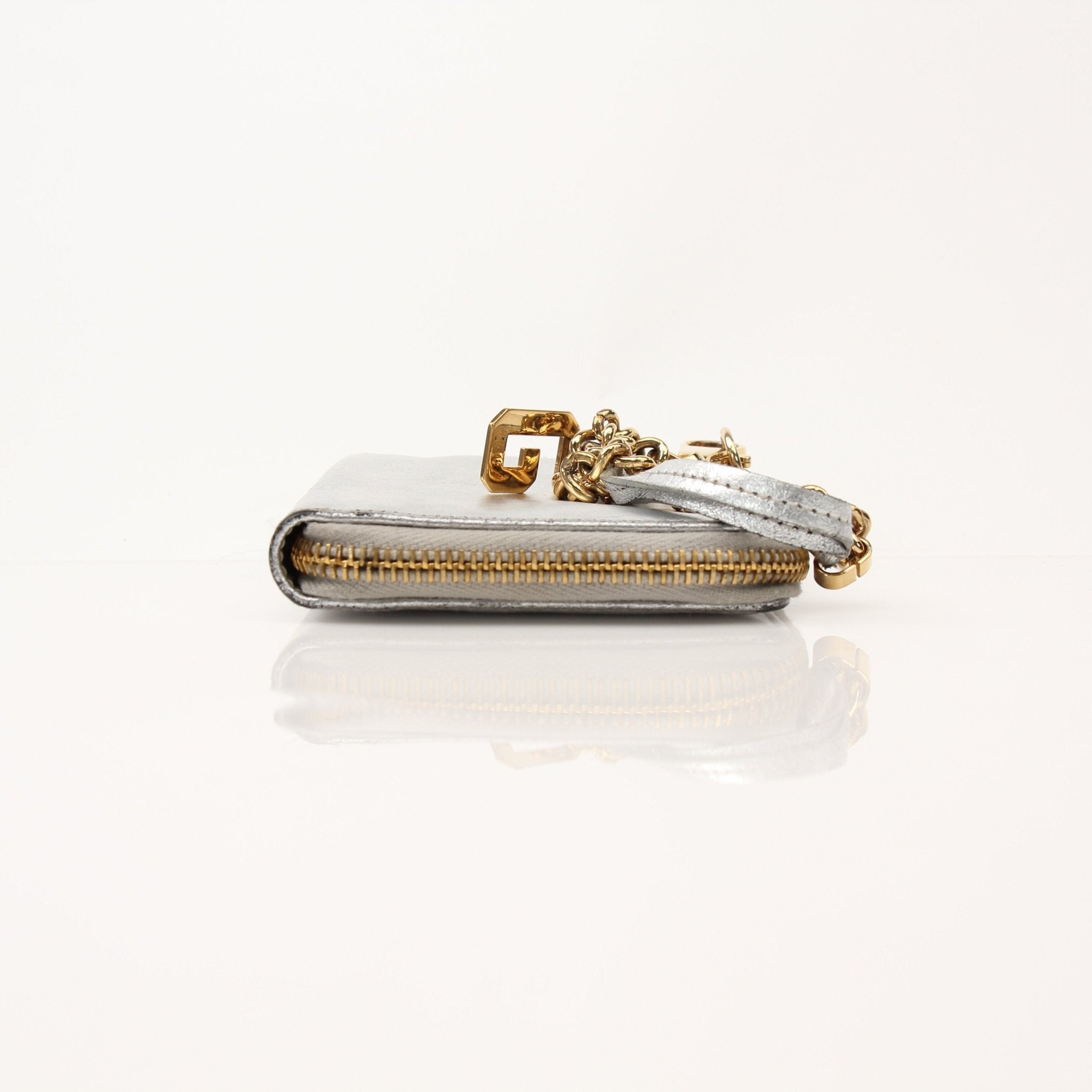 Dolce & Gabbana metallic silver zip-around wallet with gold accents and branding, featuring multiple card slots and a sleek design.