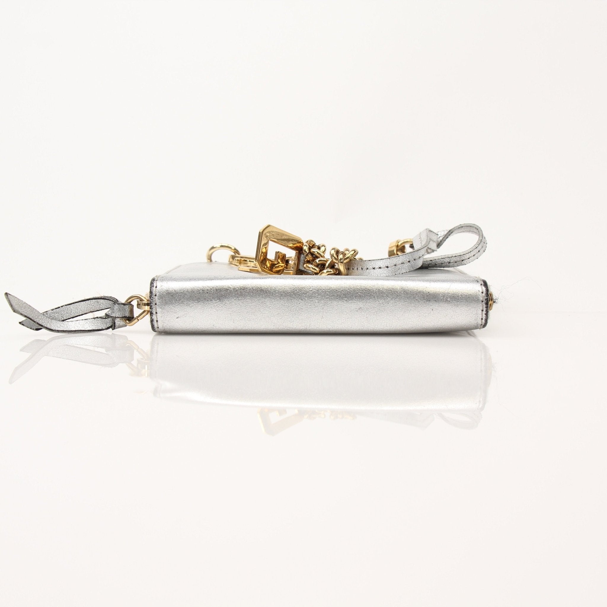 Silver metallic Dolce & Gabbana zip-around wallet with gold accents, featuring multiple card slots and a sleek design.
