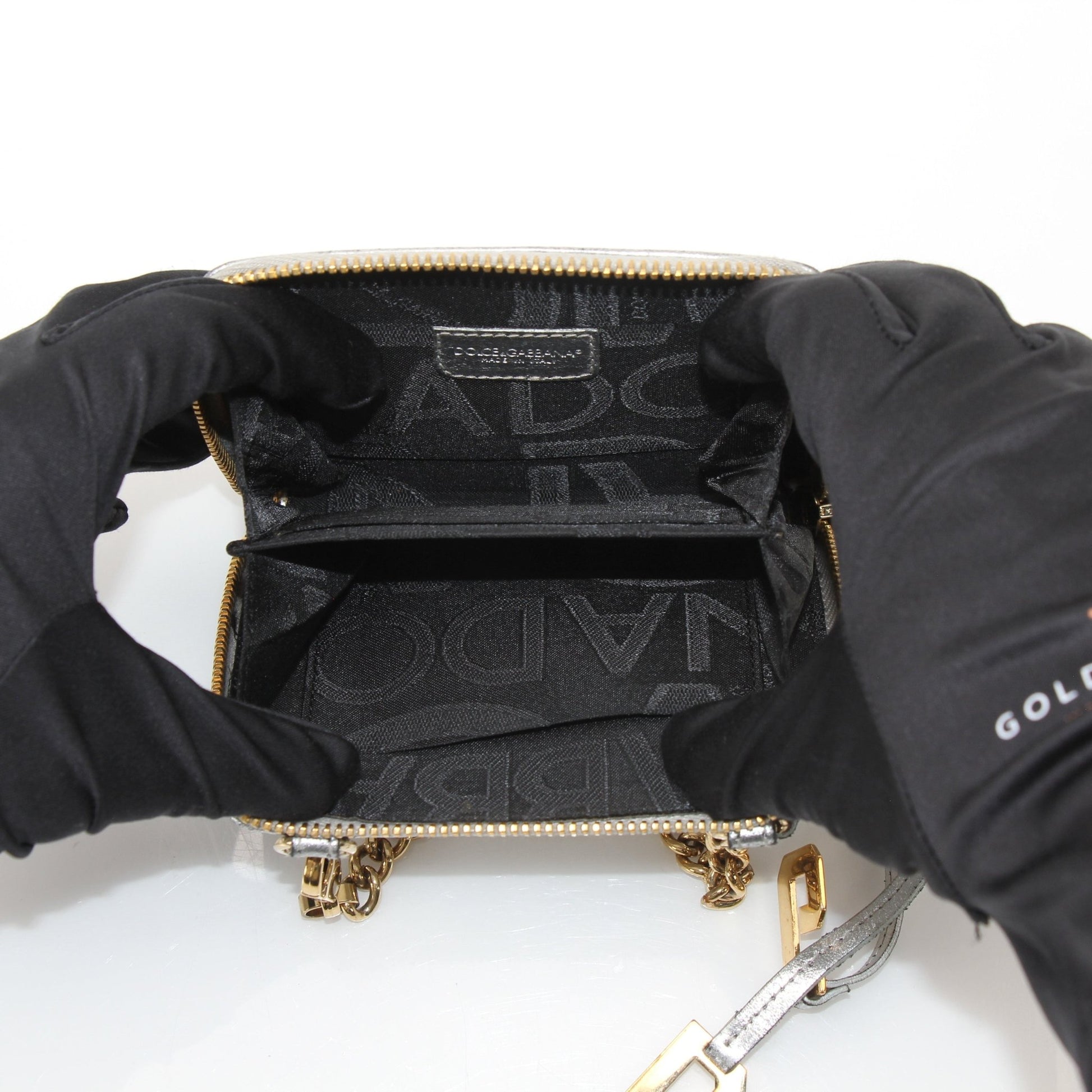 Gold & Beyond metallic silver zip-around wallet featuring a sleek design and multiple card slots, with a shiny textured finish.