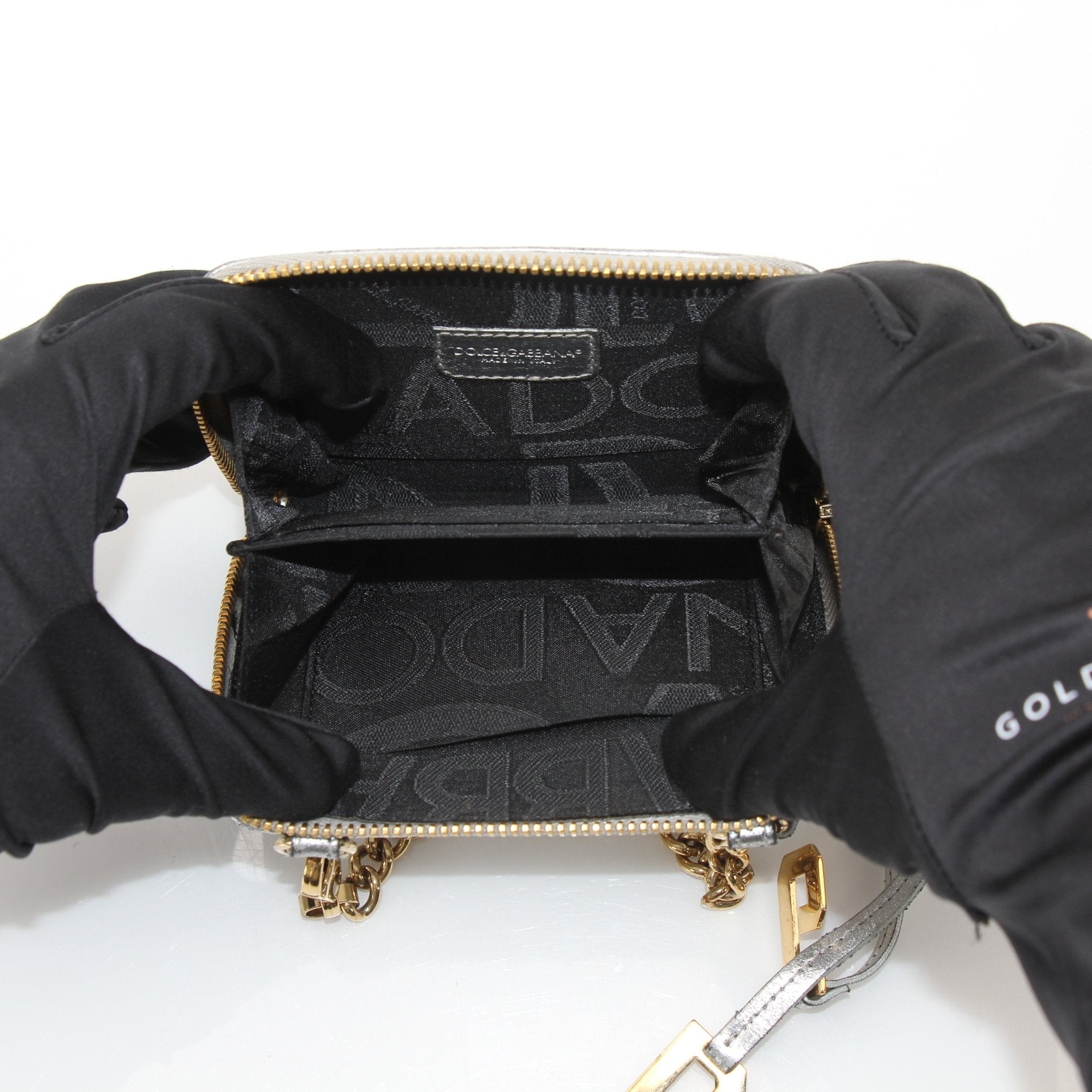 Gold & Beyond metallic silver zip-around wallet featuring a sleek design and multiple card slots, with a shiny textured finish.