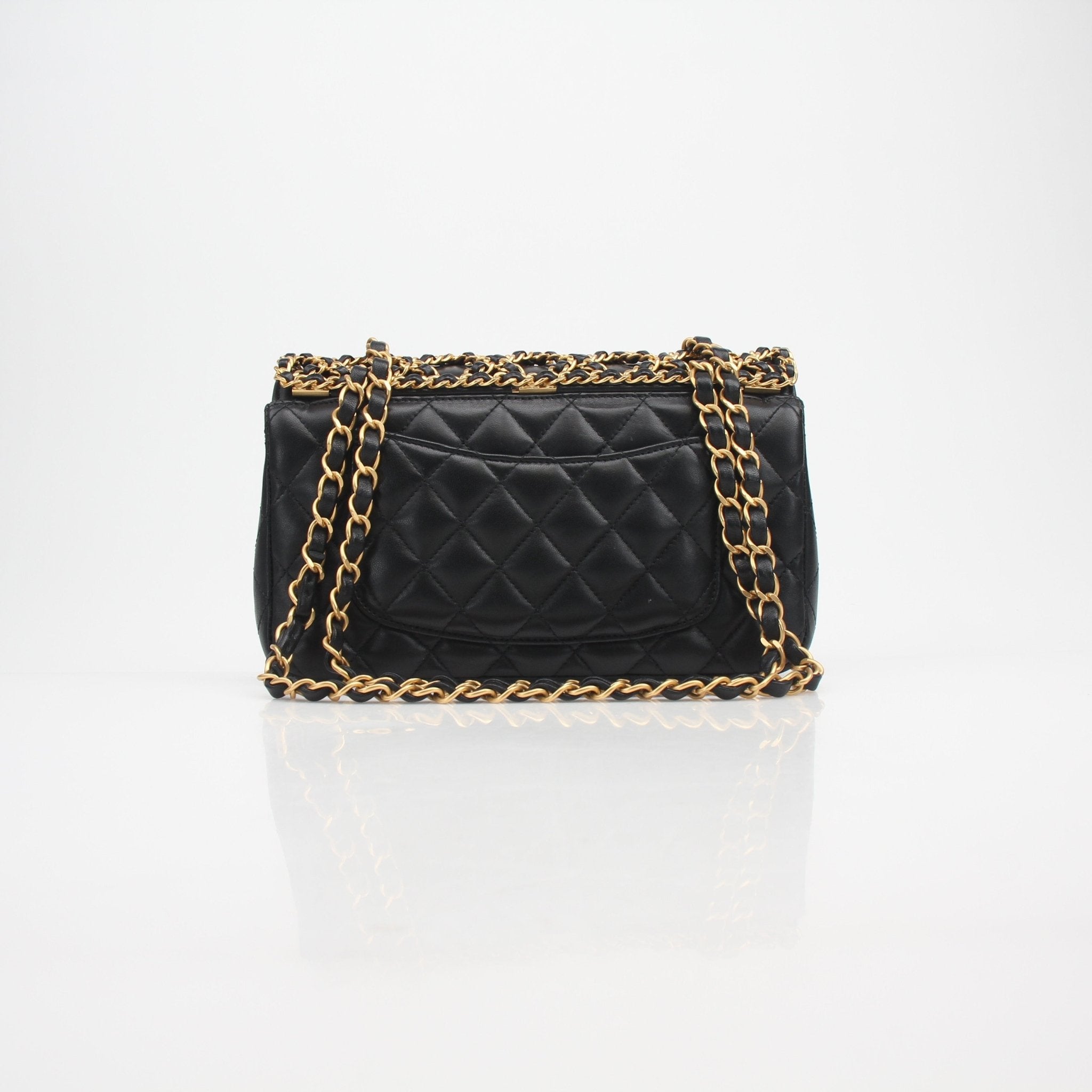 Chanel Timeless Classic black lambskin double flap handbag with gold chain strap and quilted design, showcasing elegant luxury.