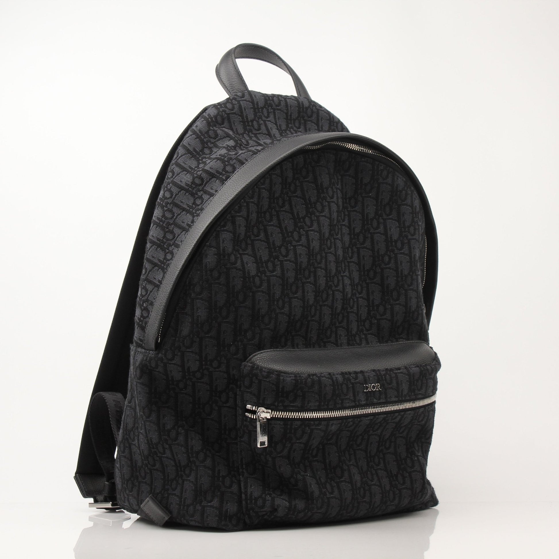 Christian Dior Oblique Canvas Backpack for travel, featuring the signature Dior pattern and sturdy leather straps.