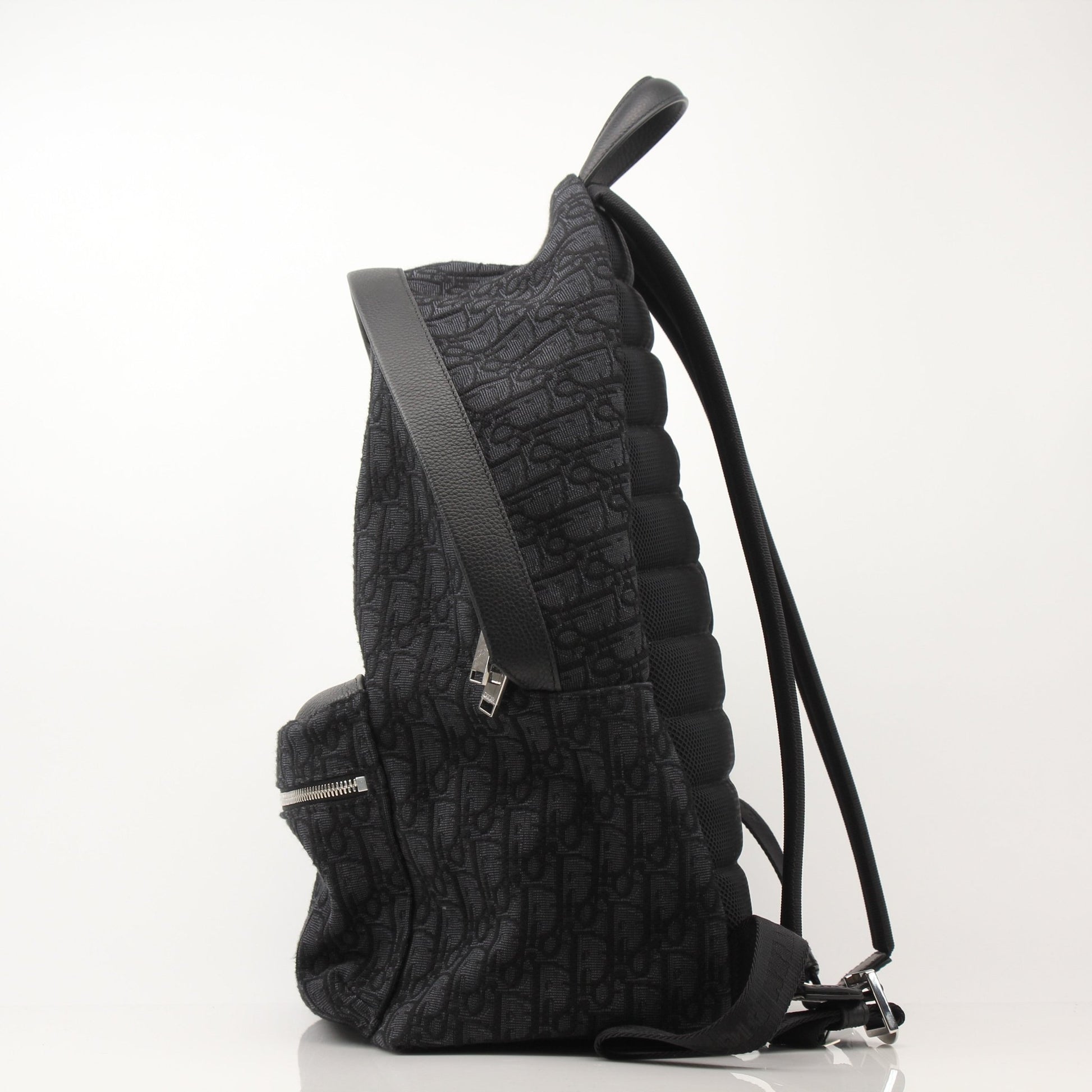 Christian Dior Oblique canvas backpack with adjustable straps and gold-tone hardware, ideal for travel and everyday use.