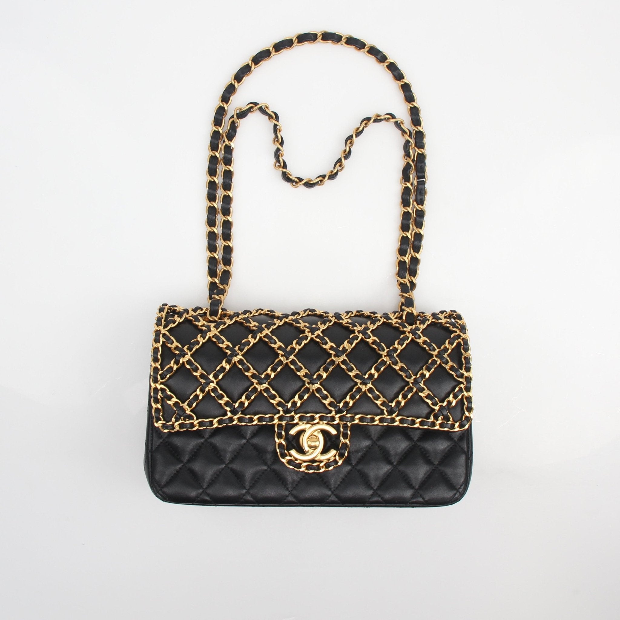 Chanel Timeless Classic black lambskin double flap handbag with chain strap, featuring gold hardware and quilted design.
