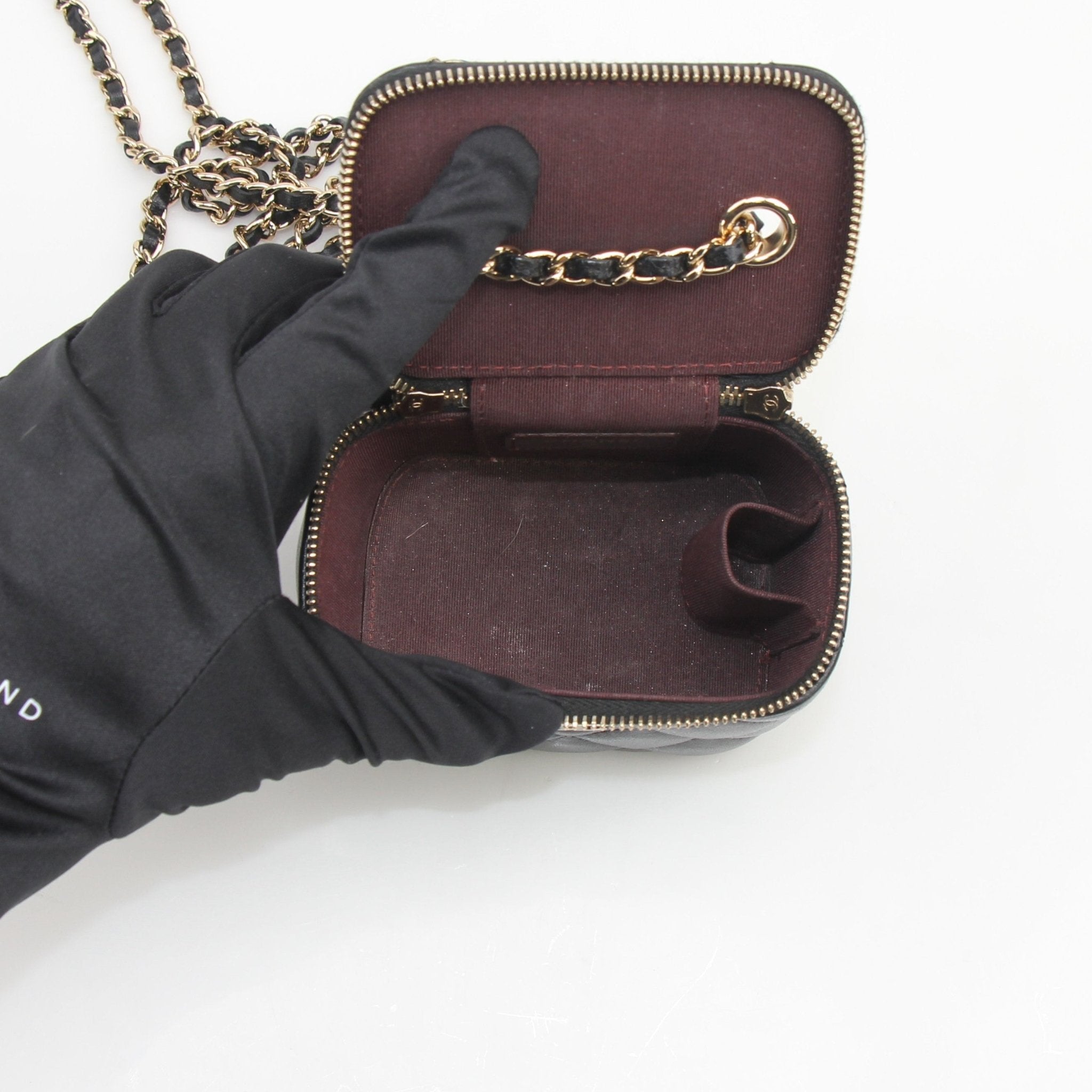 Gold & Beyond Chanel mini quilted lambskin vanity case with chain, featuring a compact design and luxurious quilted texture.