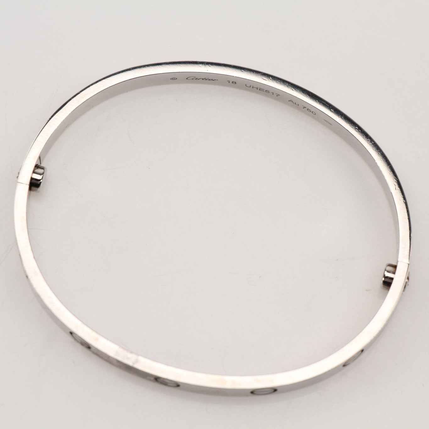 Cartier Love Bracelet in gold jewelry with screw motifs, close-up view showing the iconic design and polished finish.