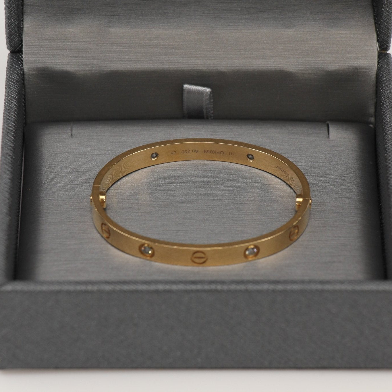 Cartier Diamond Love cuff bracelet featuring gold band and sparkling diamonds, elegant jewelry accessory.