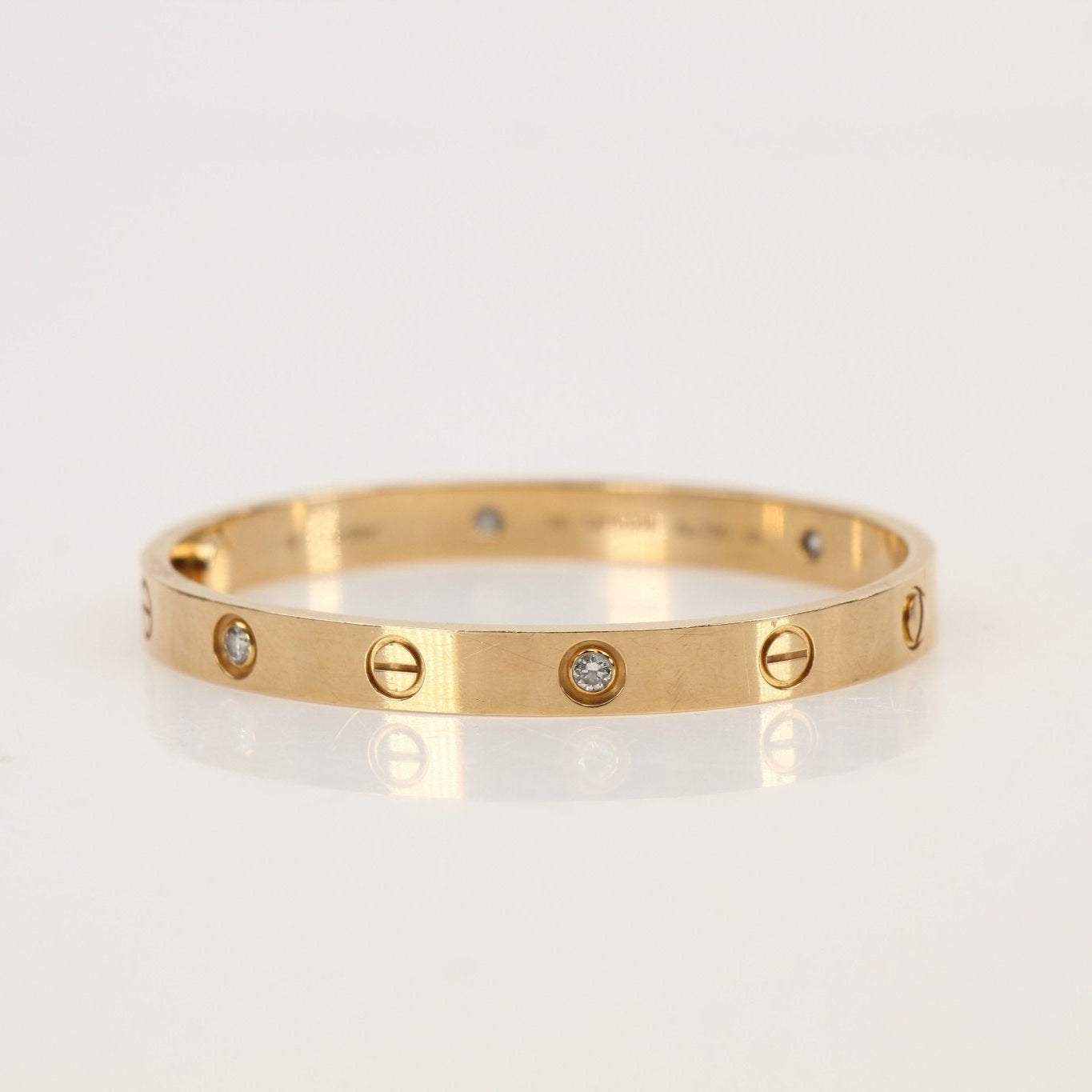 Cartier Diamond Love cuff bracelet featuring gold jewelry with sparkling diamond accents on a sleek design.