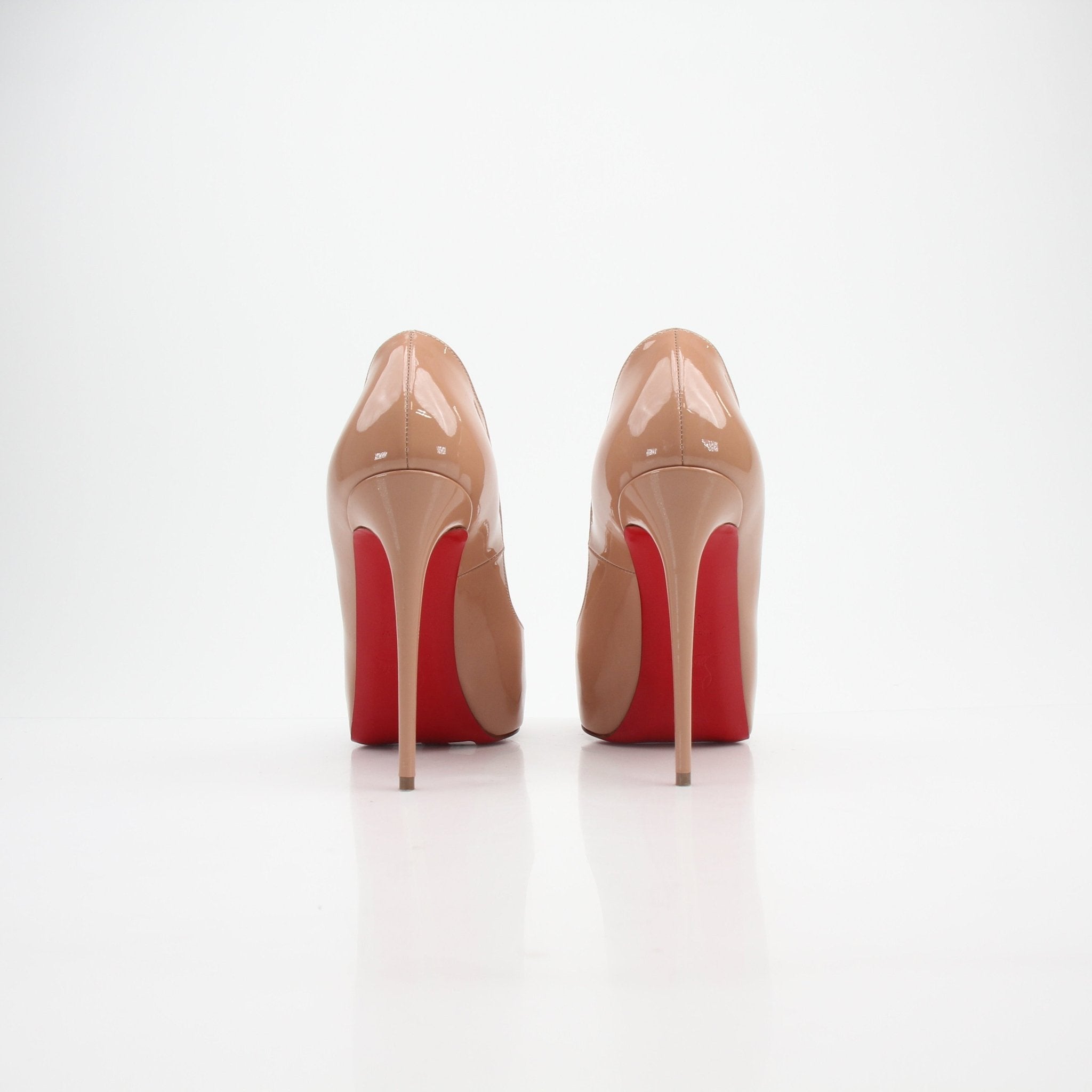 Christian Louboutin Very Privé patent leather heels with pointed toes and signature red soles, displayed on a neutral background.
