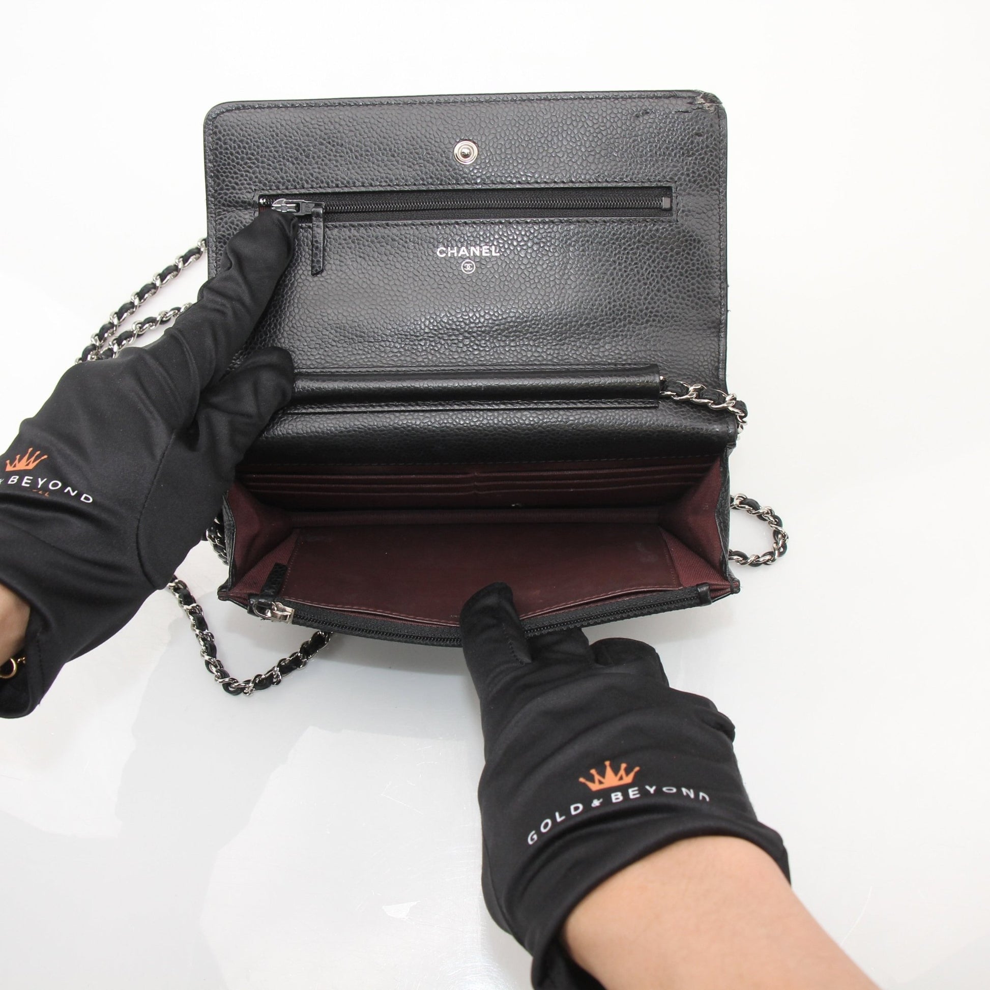 Chanel black wallet on chain with gold hardware, compact wallet with chain strap and textured leather finish.