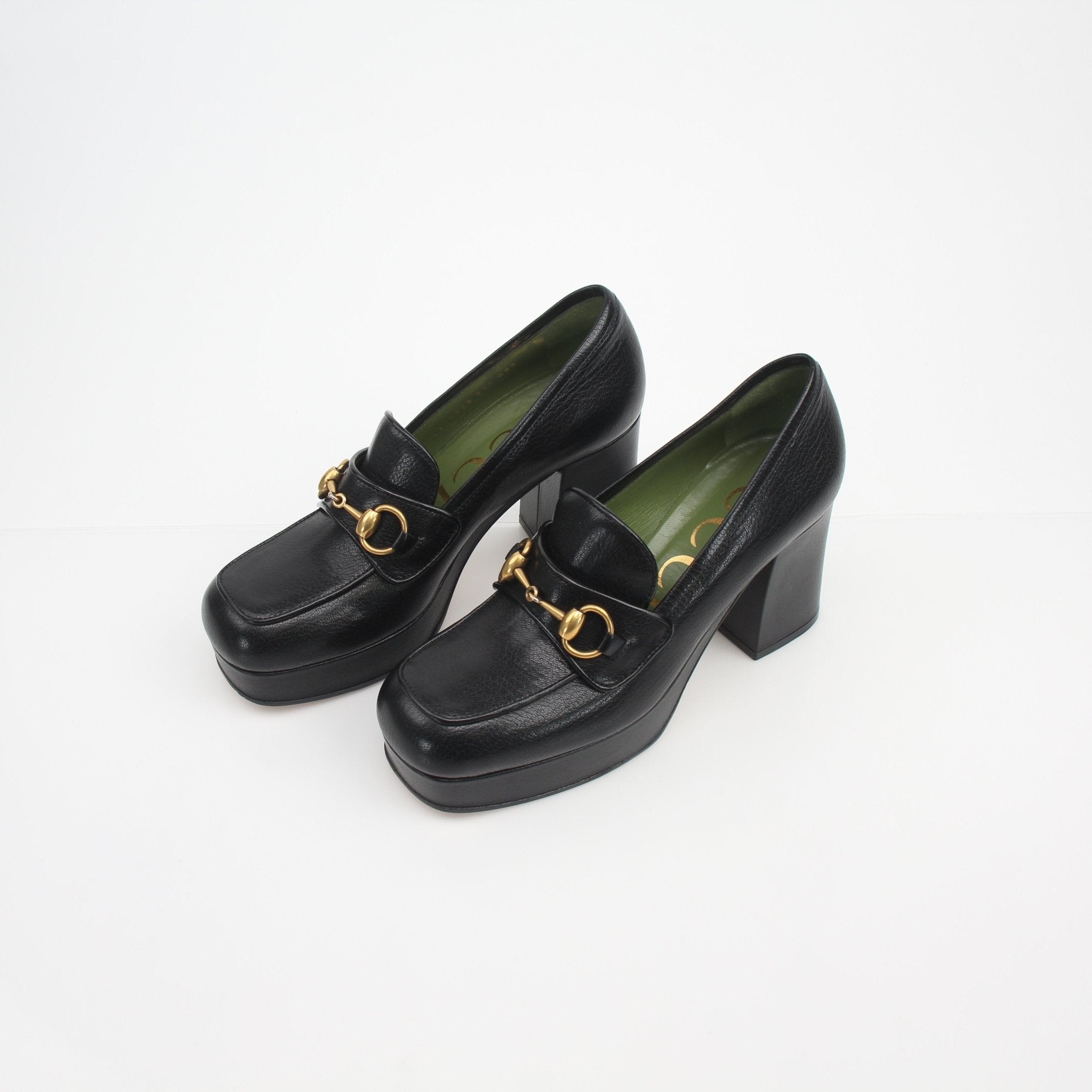 Gucci women's Houdan horsebit platform loafer pumps featuring black leather and gold hardware, displayed on a neutral background.