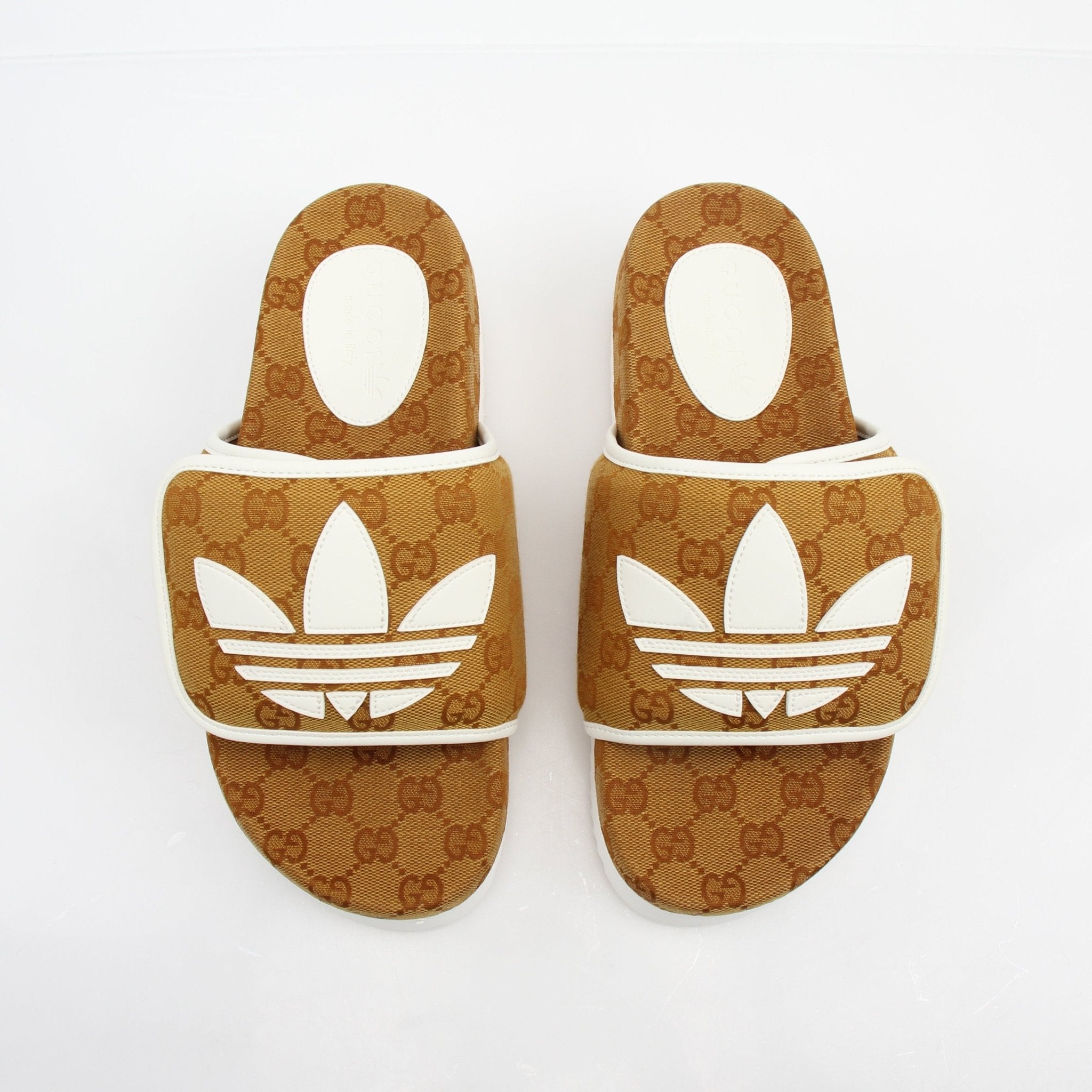 Gucci x Adidas GG Canvas Trefoil Platform Slide Sandals with bold logo design and thick platform sole, worn on feet.