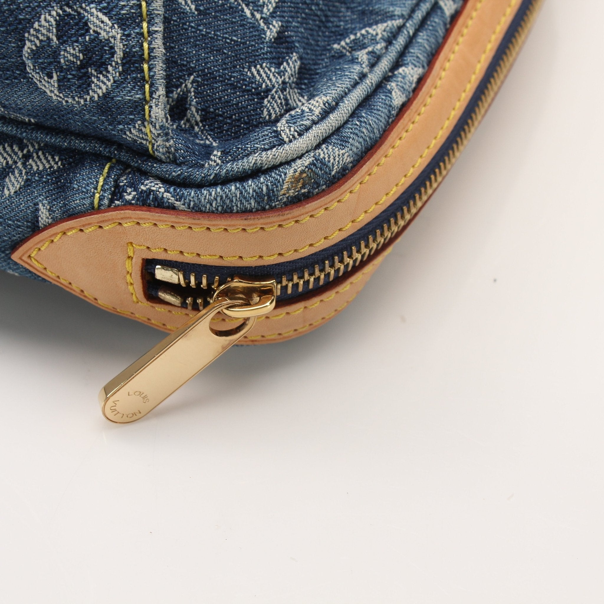 Louis Vuitton denim bum bag handbag with gold accents, featuring a stylish design and adjustable strap.