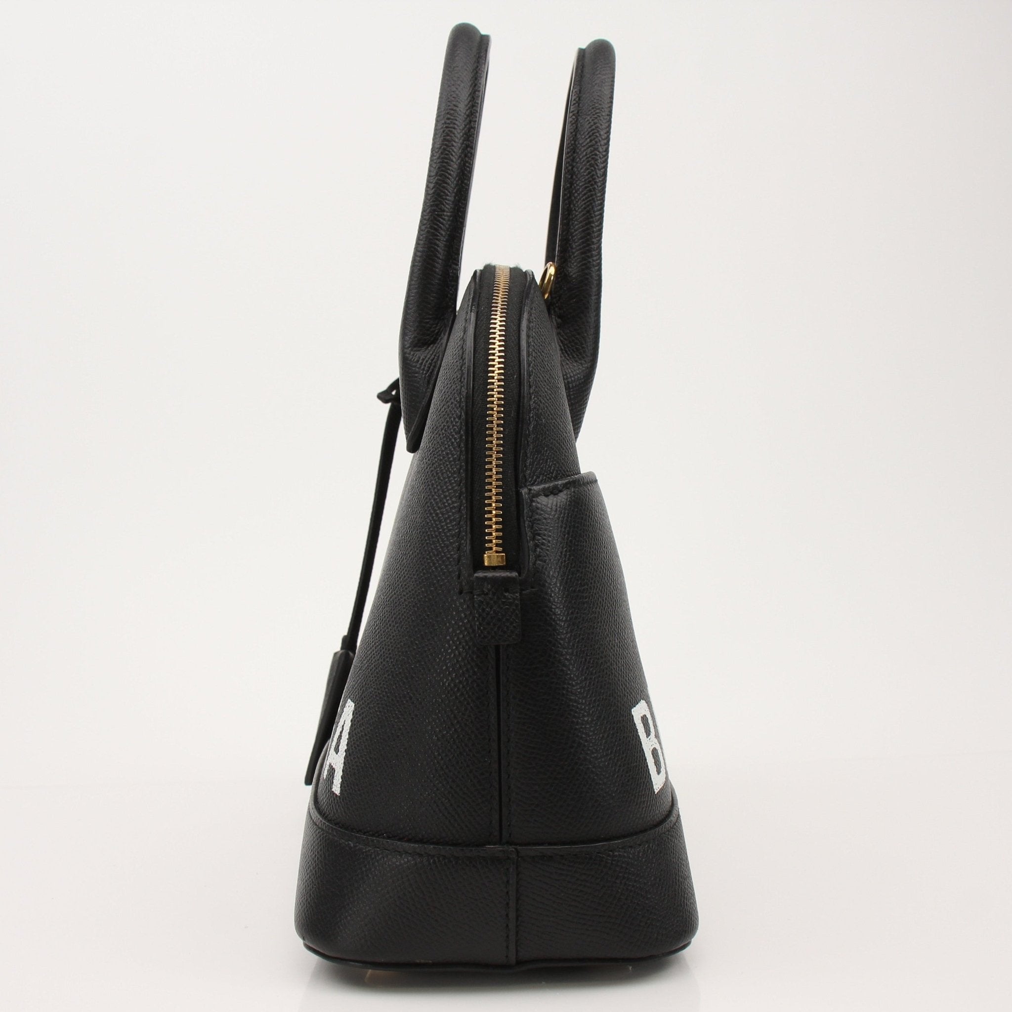 Gold & Beyond Balenciaga Ville top handle handbag with structured design and gold-tone hardware on a plain background.