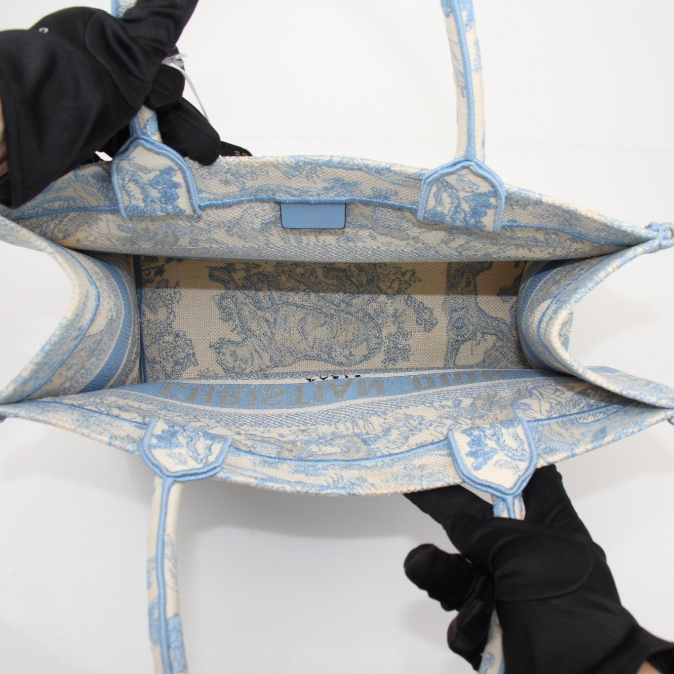 Christian Dior medium book tote bag in white and blue embroidered canvas, featuring a stylish handbag design.