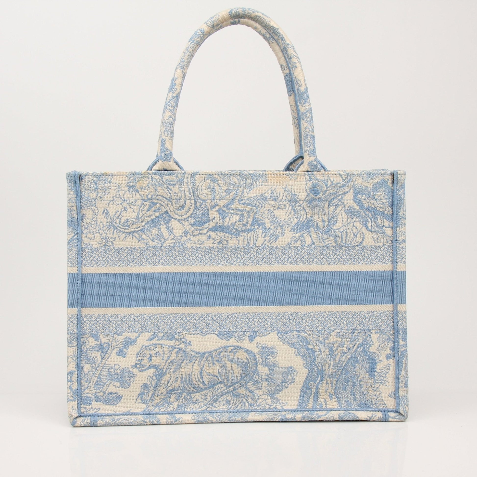 Christian Dior Book Tote handbag with gold accents and floral pattern, showcasing elegant design and spacious interior.