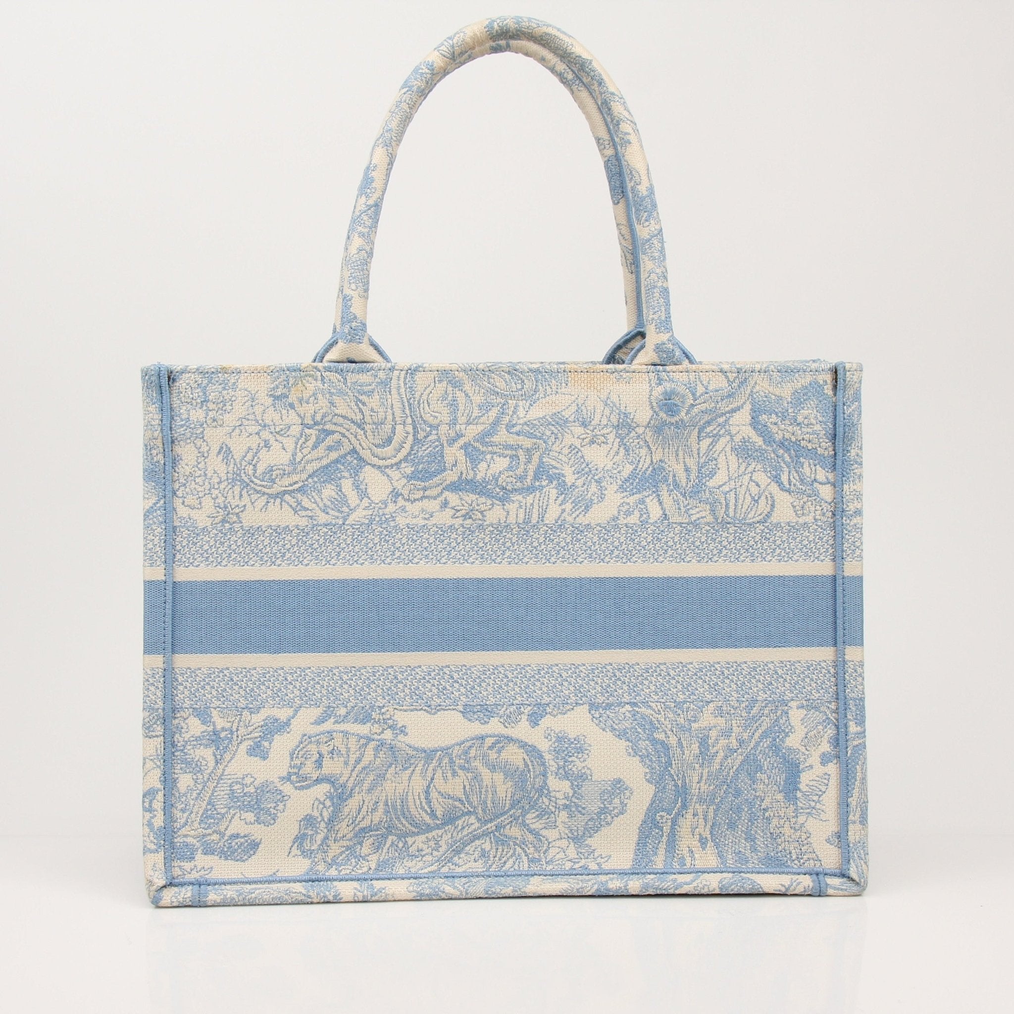 Christian Dior Book Tote handbag with gold accents and floral pattern, showcasing elegant design and spacious interior.