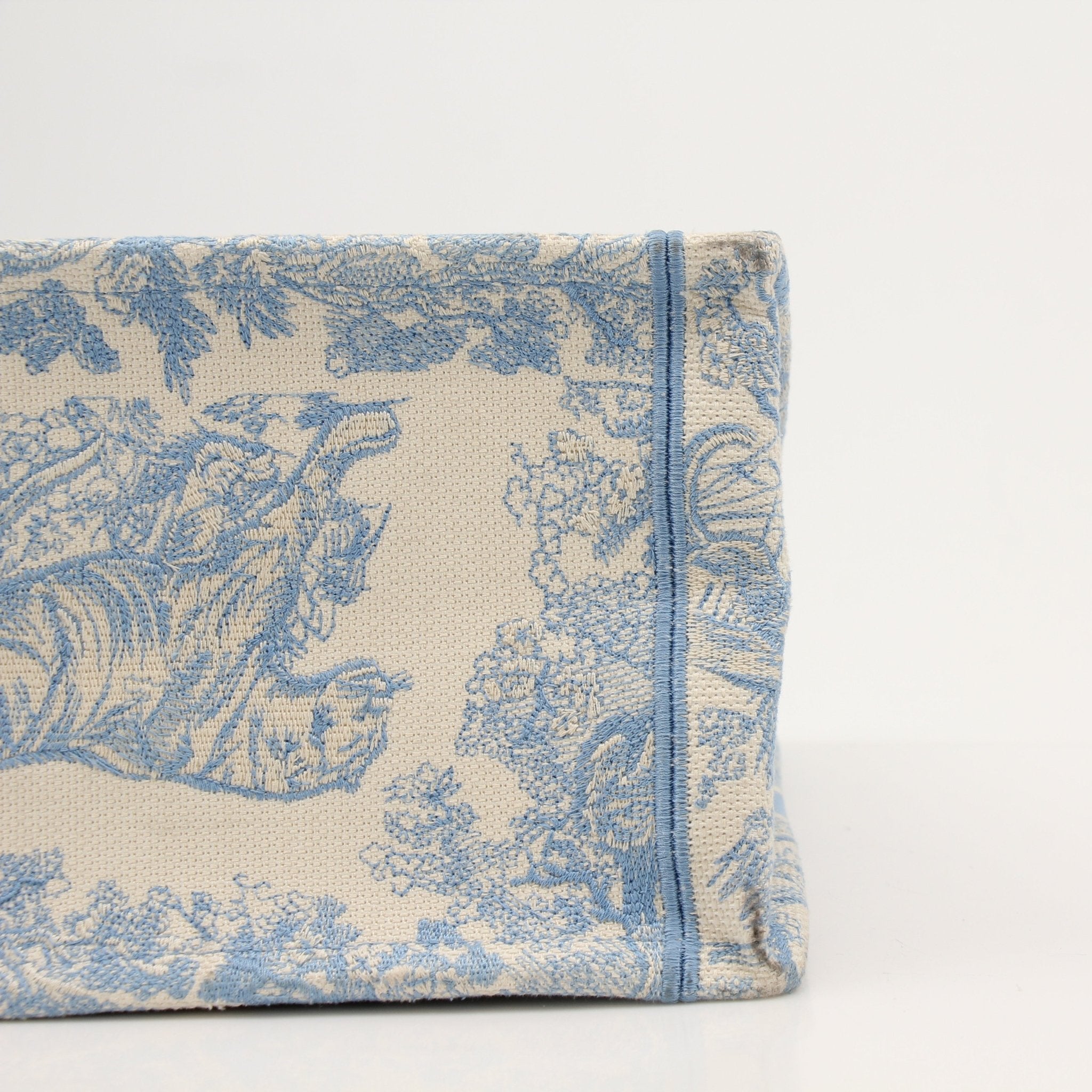 Christian Dior Book Tote handbag with gold accents, showcasing elegant design and craftsmanship in this close-up image.