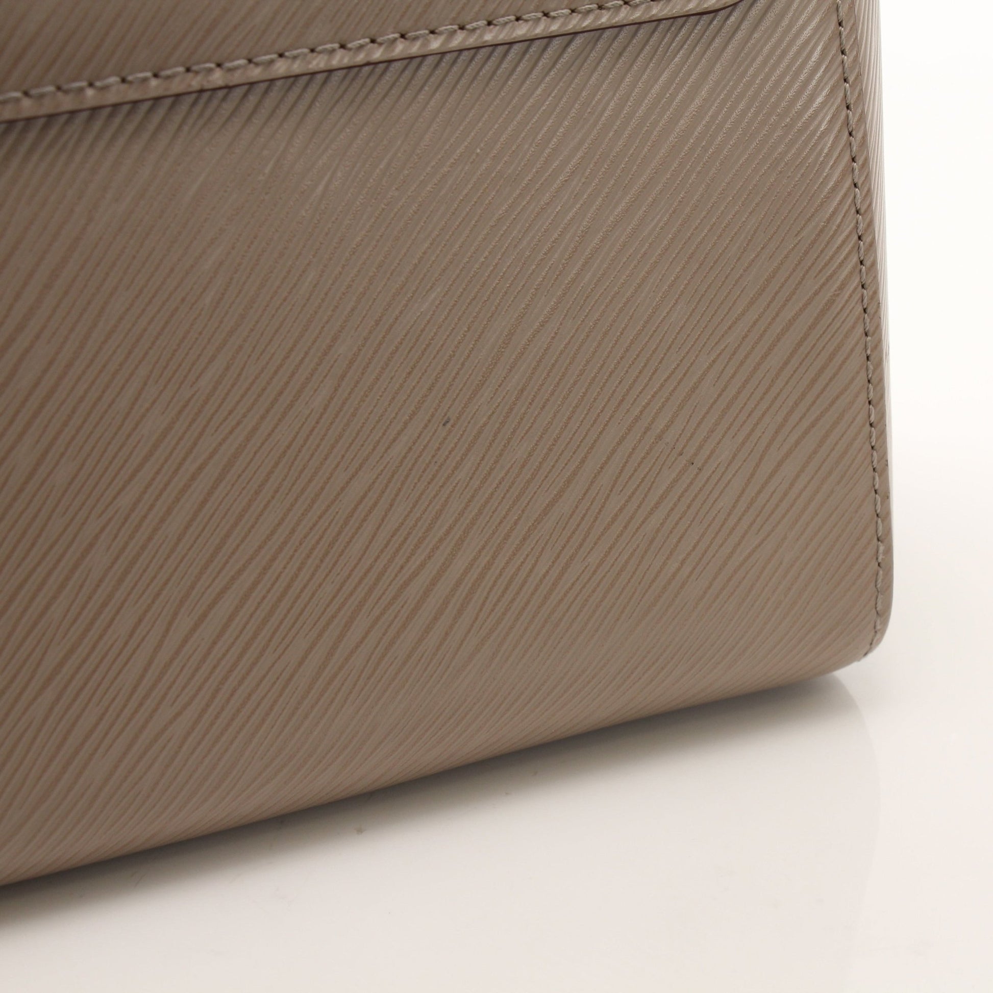 Beige Louis Vuitton Twist MM shoulder handbag with gold hardware, featuring a structured design and signature LV clasp.