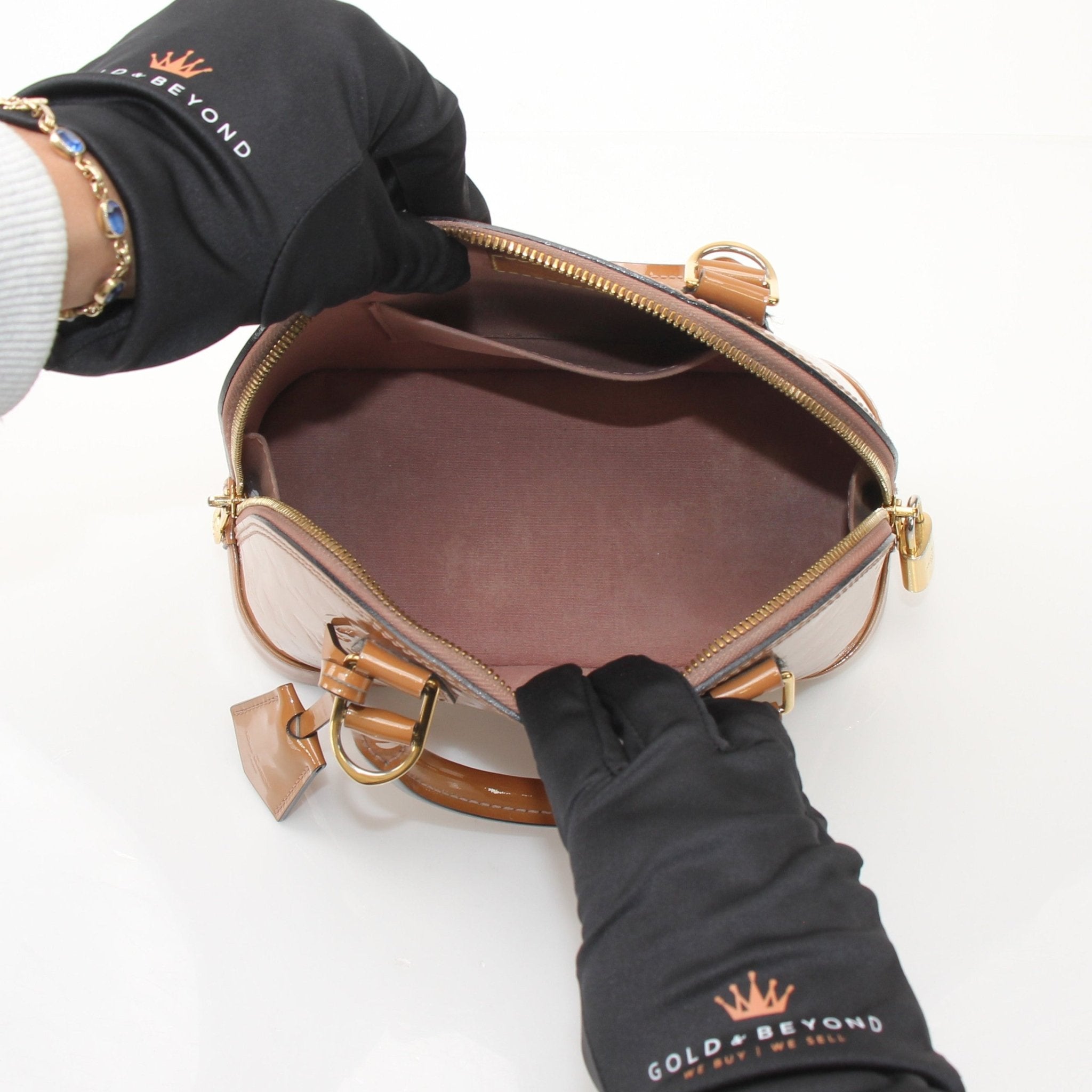 Louis Vuitton Rose Vernis Alma BB handbag with gold hardware, showcasing glossy pink leather and structured design.