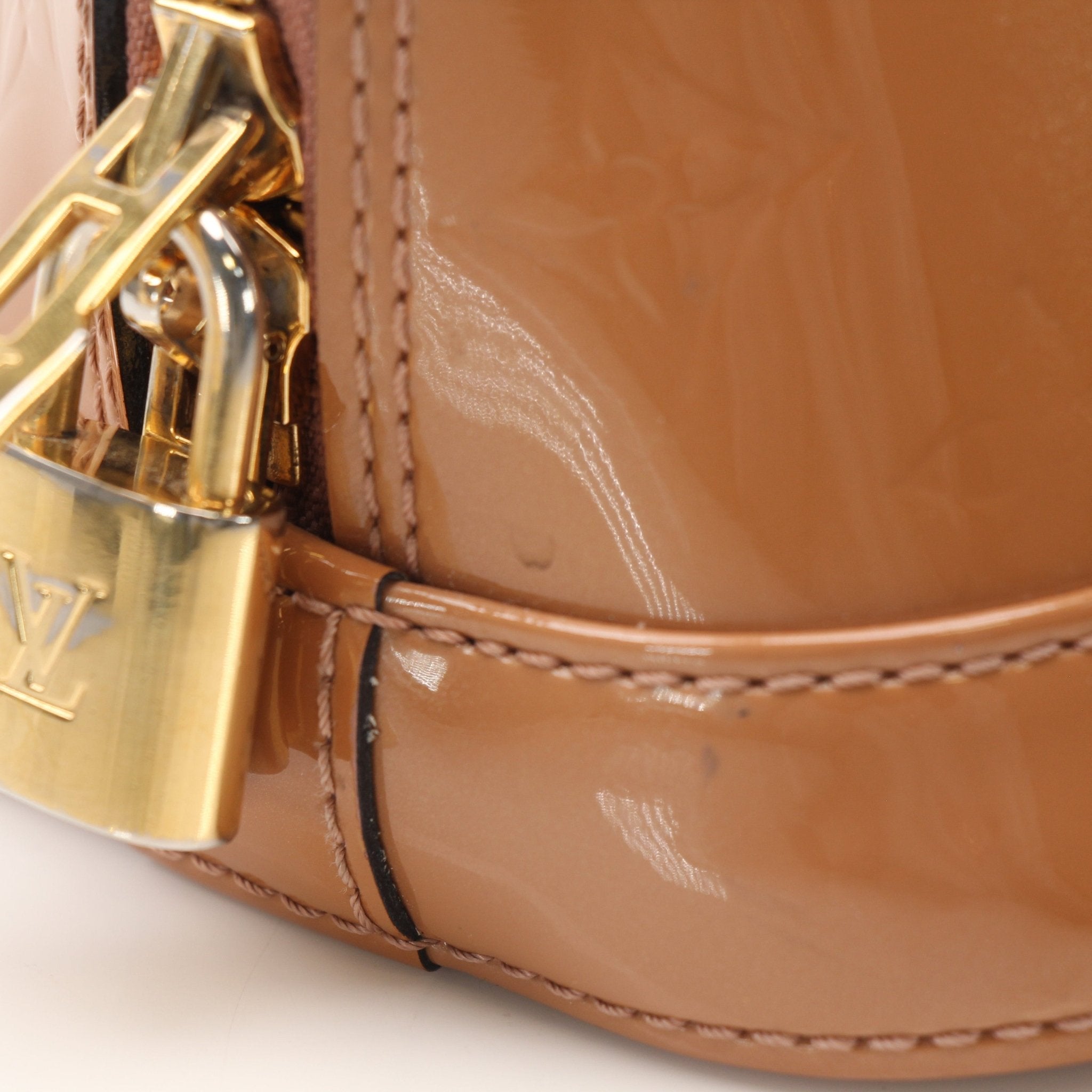 Louis Vuitton Rose Vernis Alma BB handbag with gold hardware, glossy finish, top handles, and zip closure.