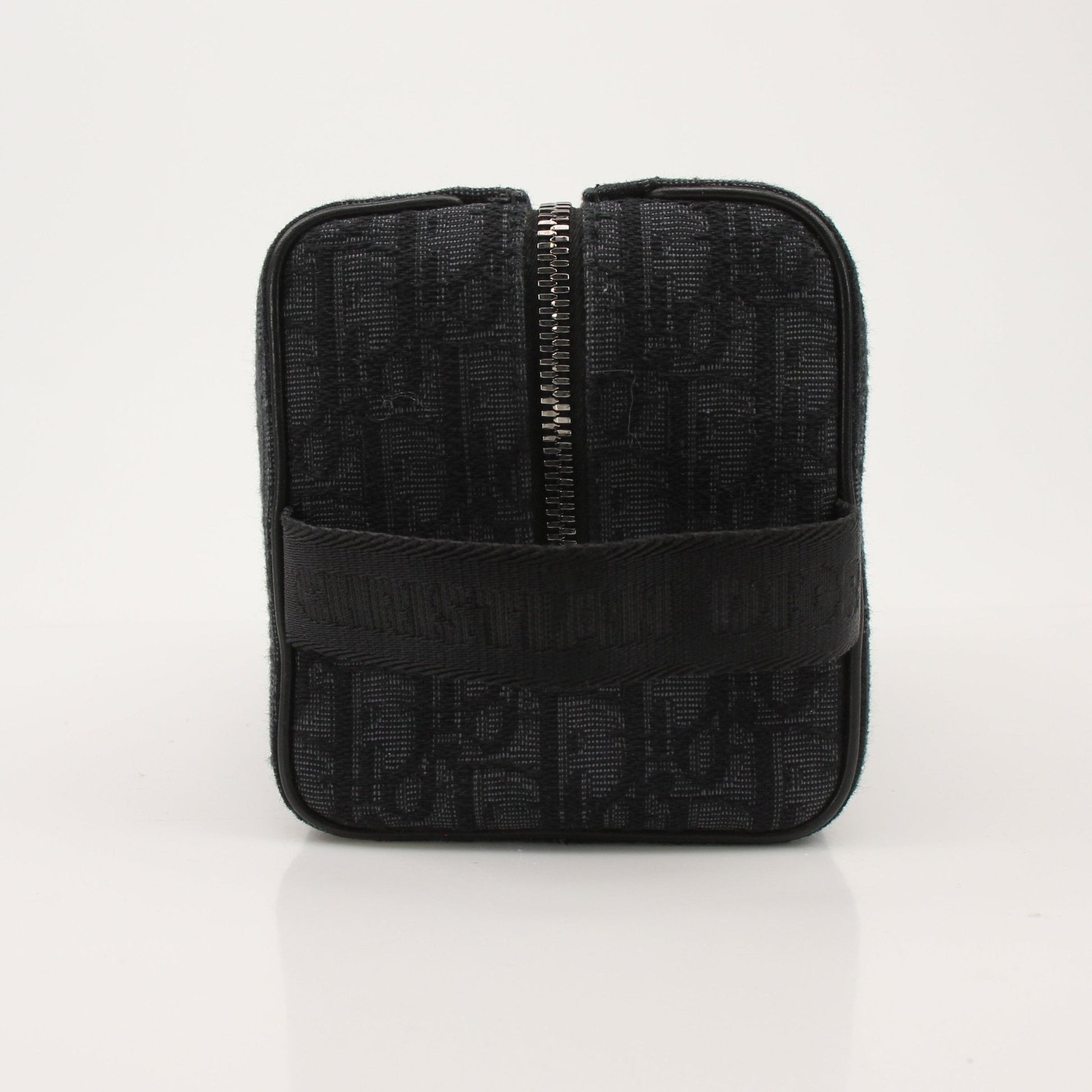 Christian Dior Dior Oblique toiletry bag in beige and brown fabric with leather accents, designed for compact storage.