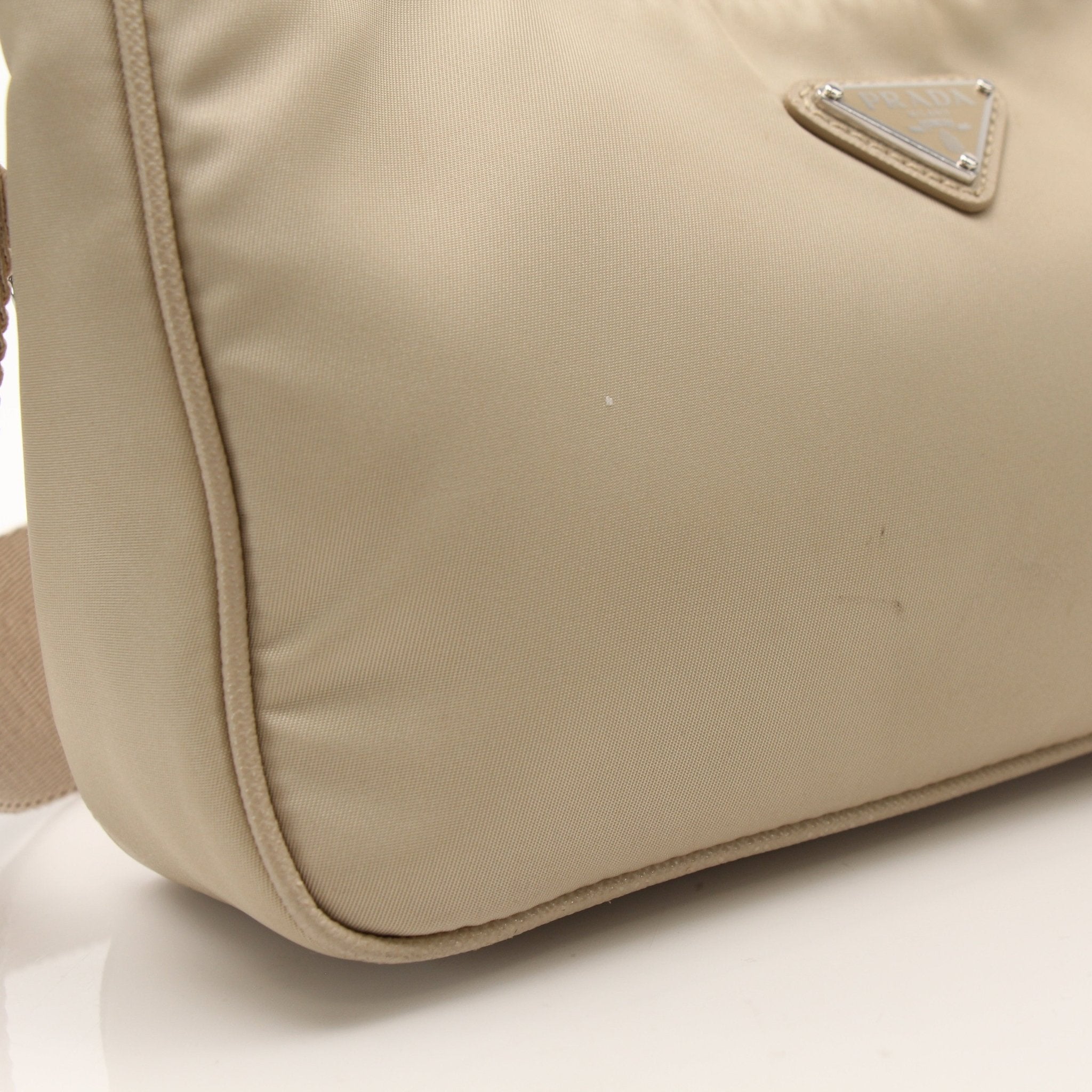 Prada Re-Edition 2005 Re-Nylon shoulder handbag with top handle and sleek design, shown in black with gold-tone hardware.