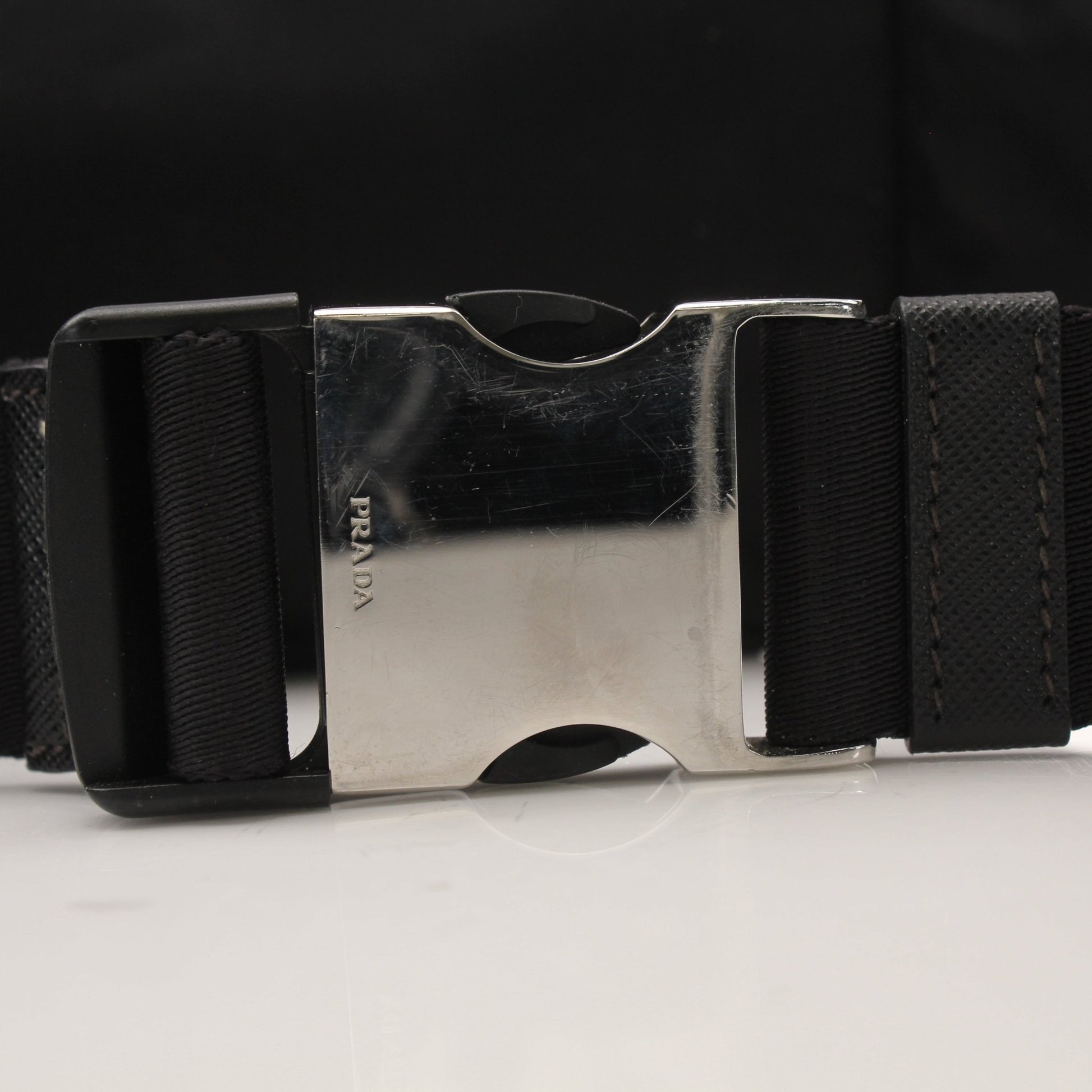 Gold & Beyond Prada Re-Nylon belt bag handbag with adjustable strap and sleek design, shown in a close-up view.