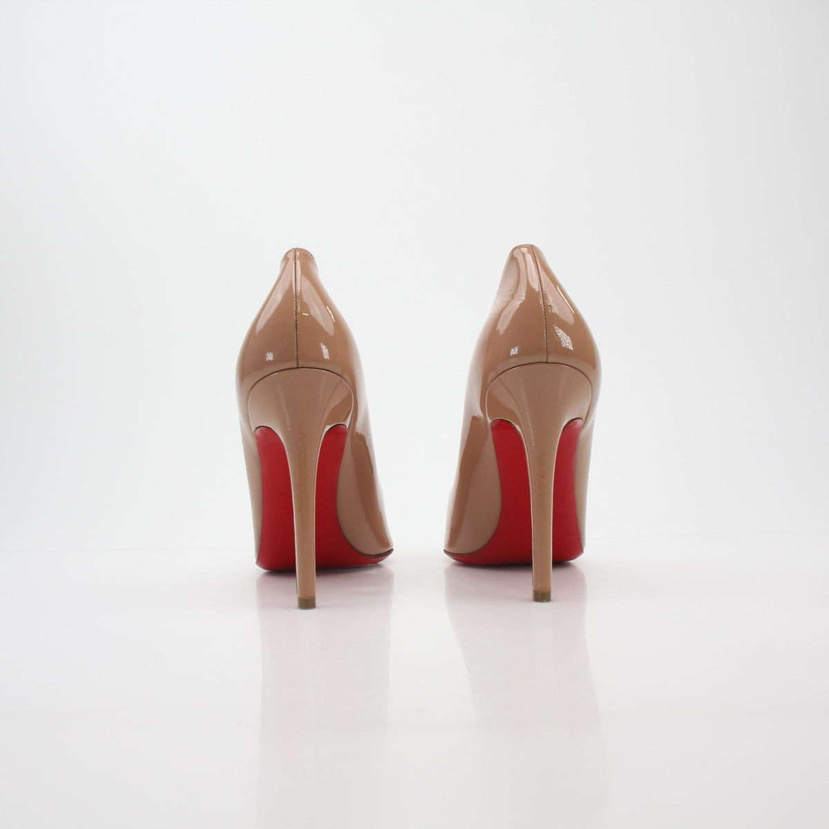 Christian Louboutin Nude Pigalle 100 patent leather pumps, elegant high heels with signature red soles and sleek design.