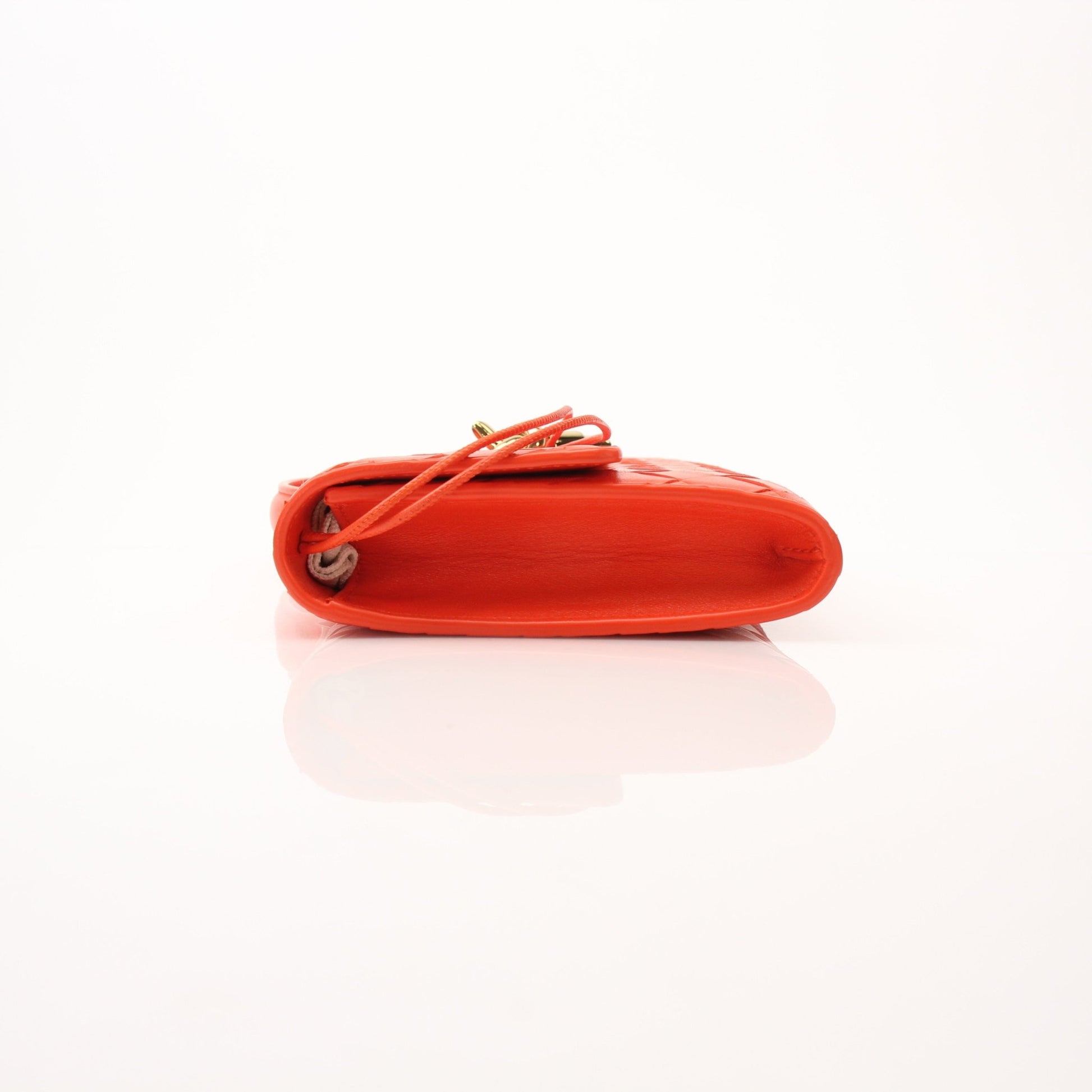 Gold Bottega Veneta Andiamo clutch handbag with woven leather design, shown in a close-up view.
