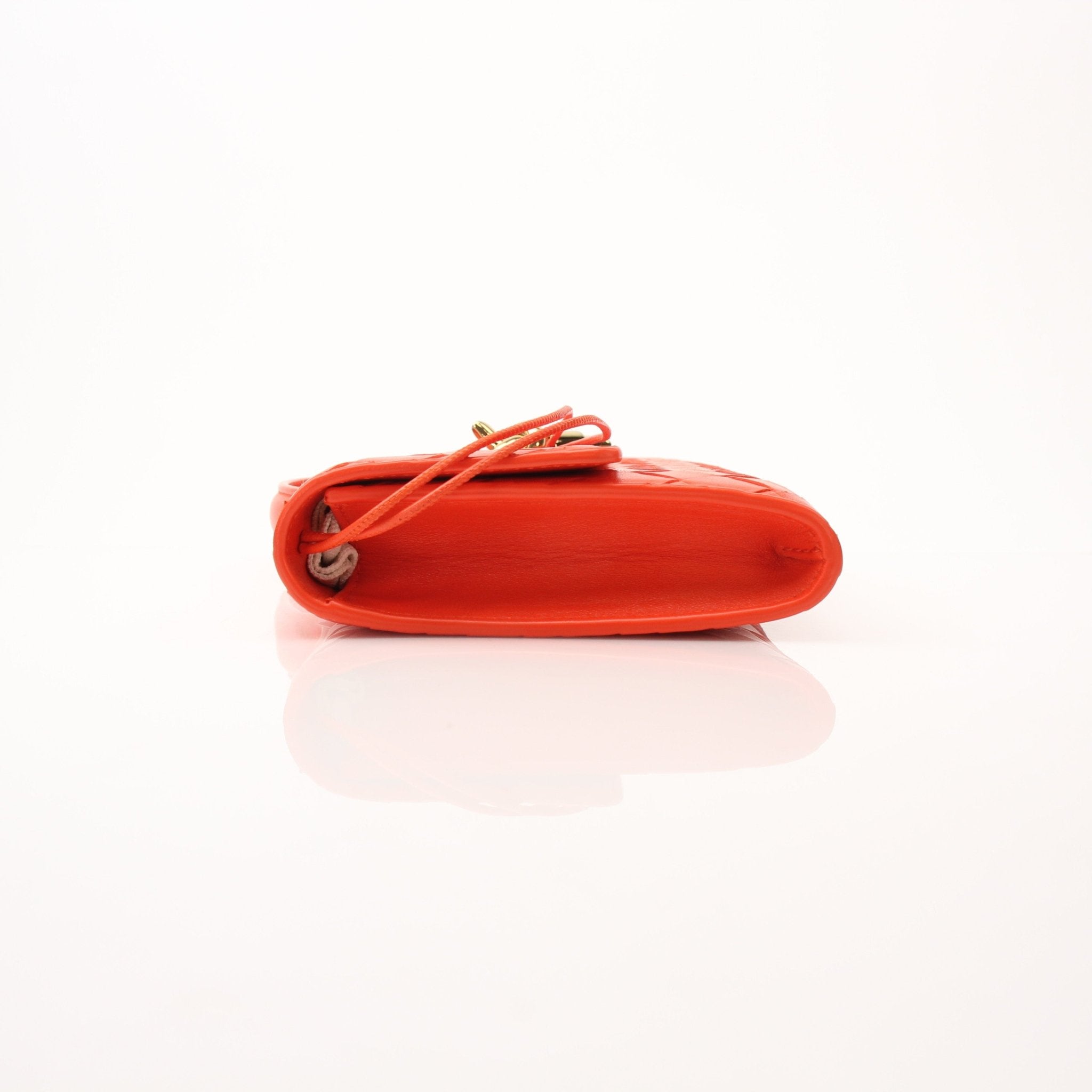 Gold Bottega Veneta Andiamo clutch handbag with woven leather design, shown in a close-up view.