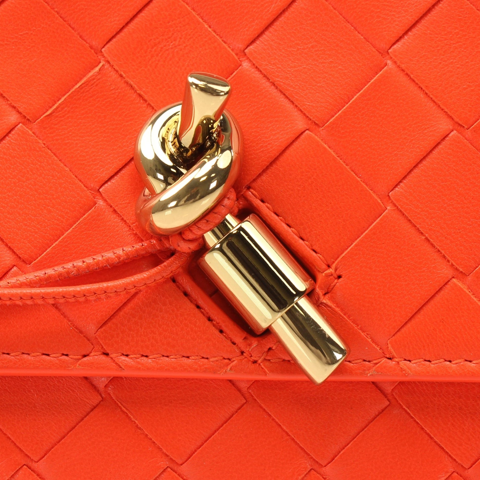 Gold and Beyond Bottega Veneta Andiamo clutch handbag with woven leather design and gold-tone hardware.