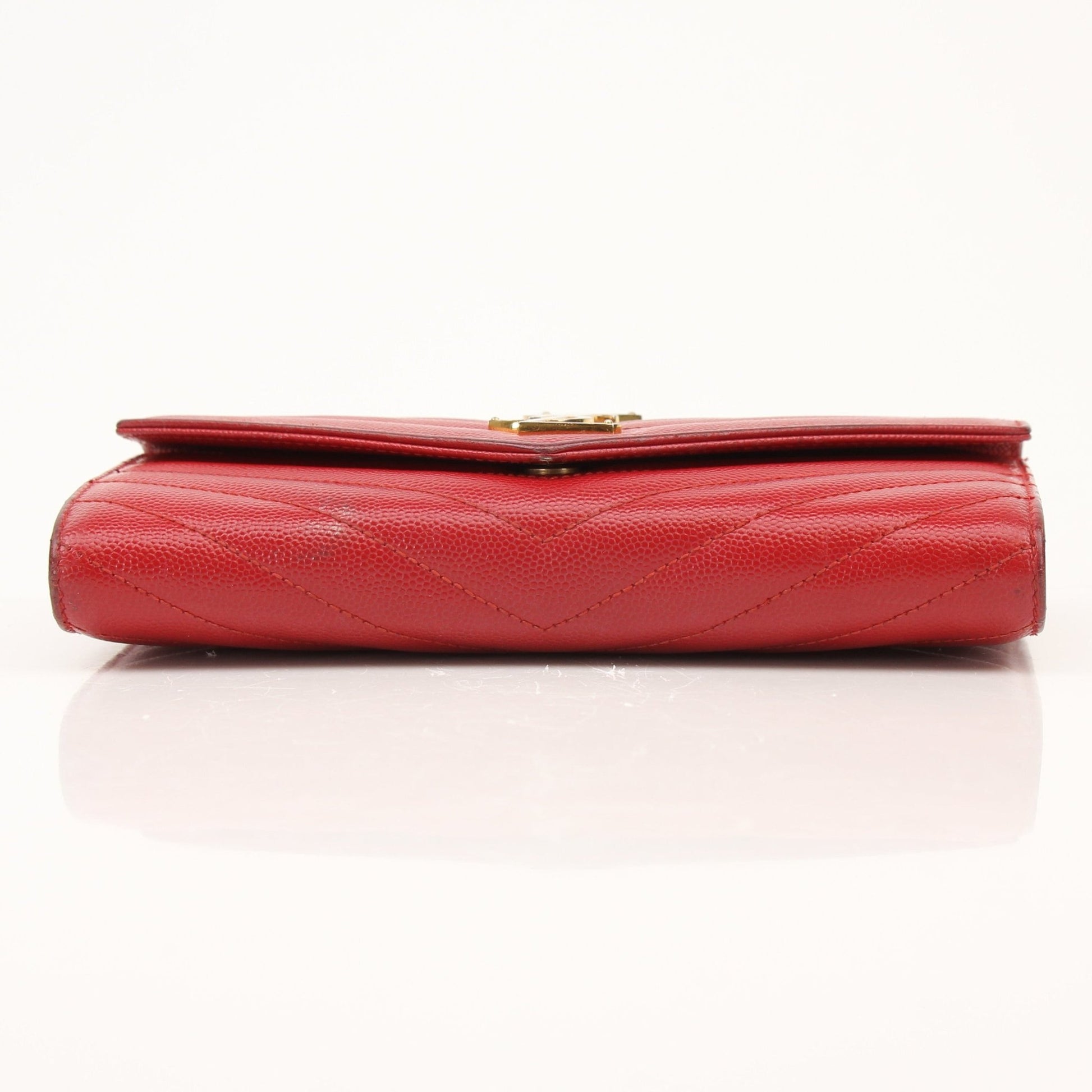 Saint Laurent red envelope chain wallet with flap closure, featuring a sleek design and gold-tone chain detail.