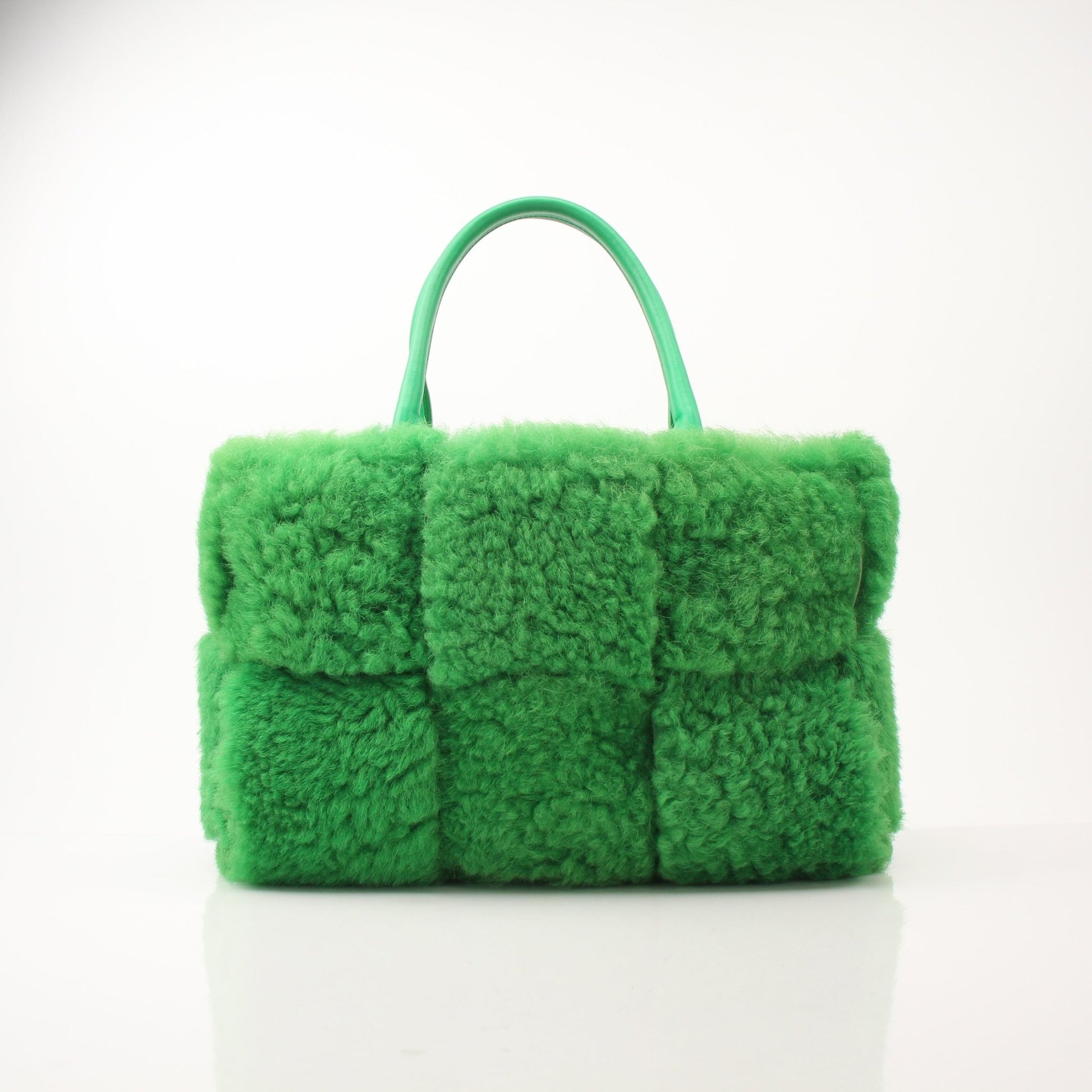 Green Bottega Veneta Arco Tote handbag with structured design and top handles, displayed with a neutral background.
