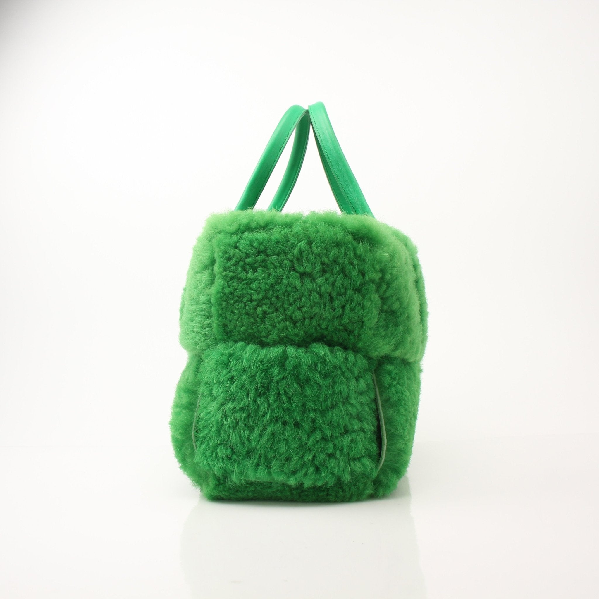 Green Bottega Veneta Arco Tote handbag with structured design and gold accents, shown on a white background.