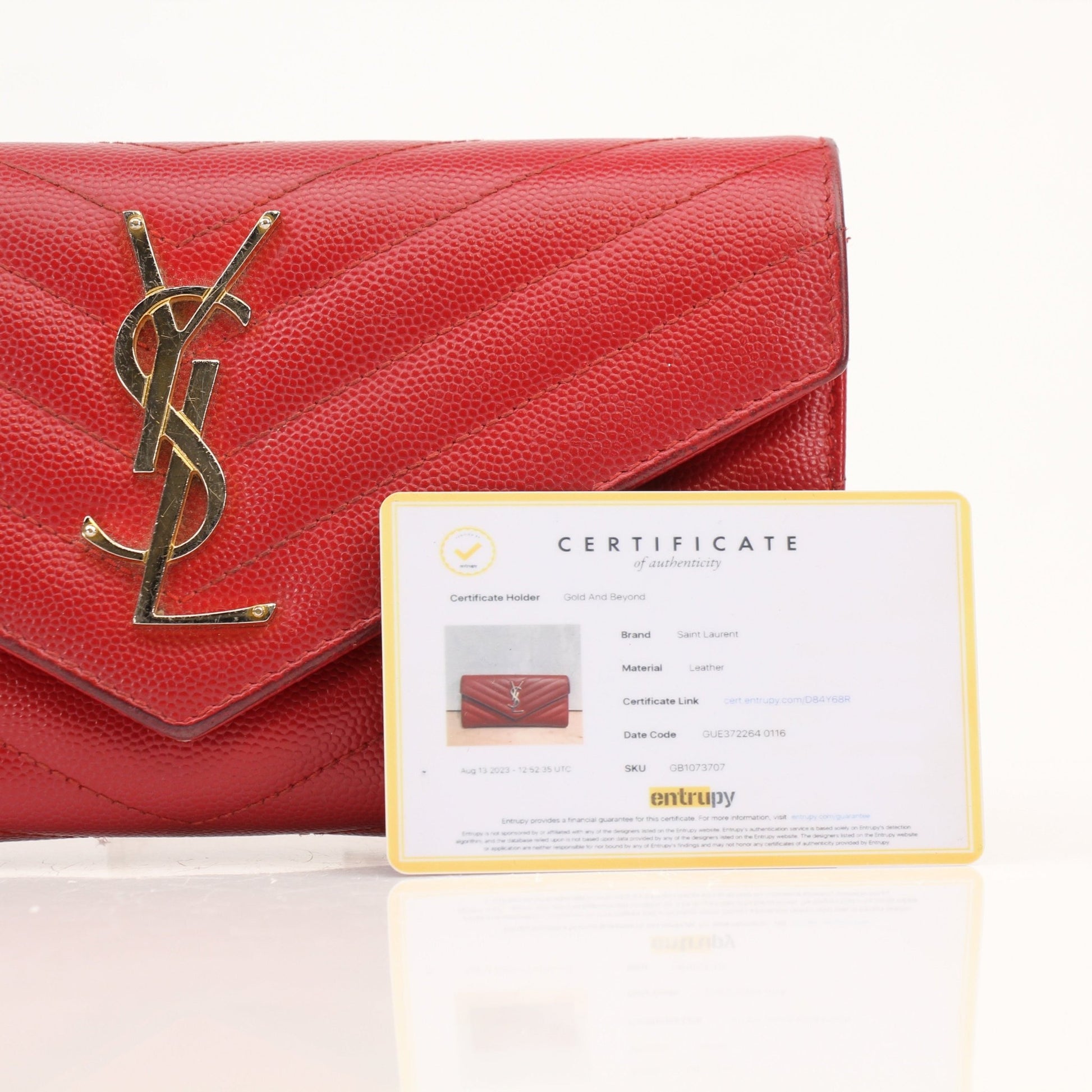 Red Saint Laurent envelope chain wallet with flap closure, featuring gold accents and compact design for stylish everyday use.