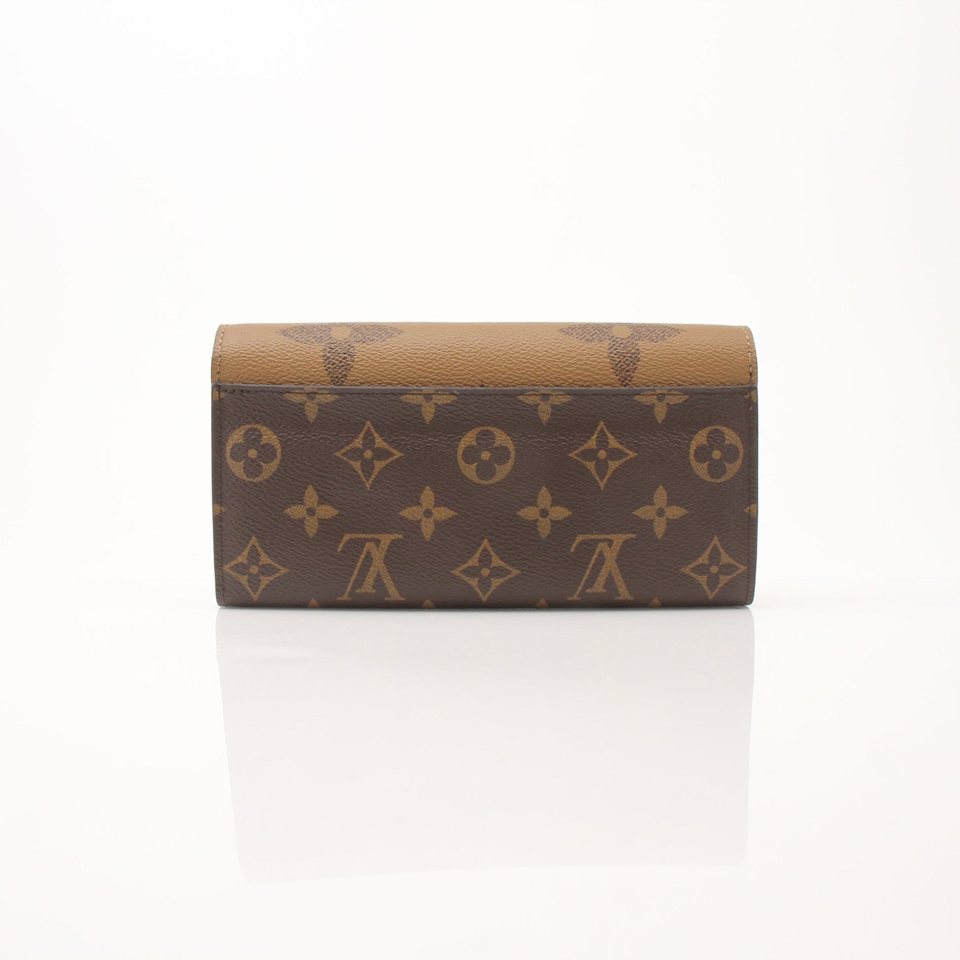 Louis Vuitton reverse monogram wallet with gold accents, featuring multiple card slots and a sleek, compact design.