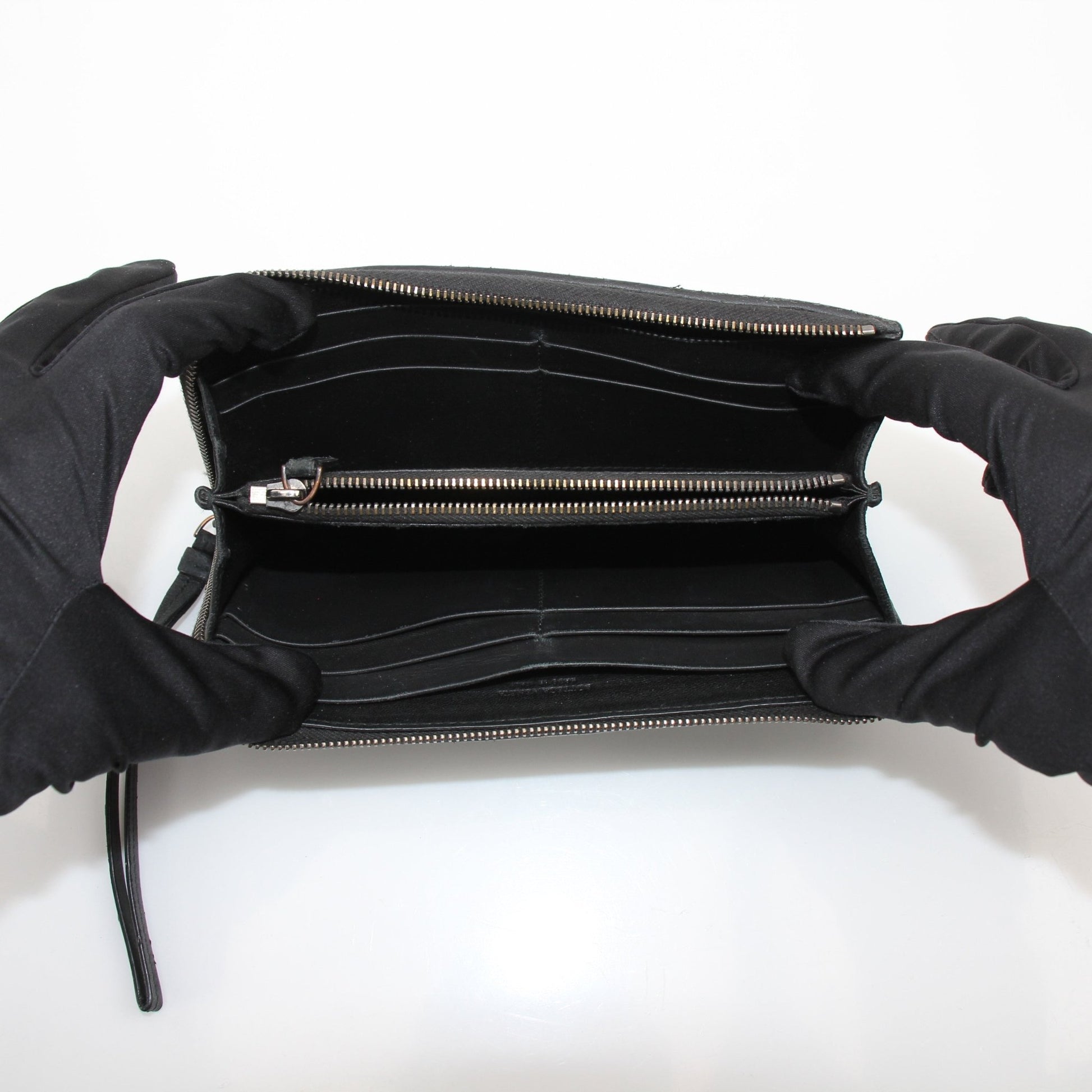 Black Bottega Veneta Nero Intrecciato leather wallet with woven design, featuring a sleek, high-quality texture.