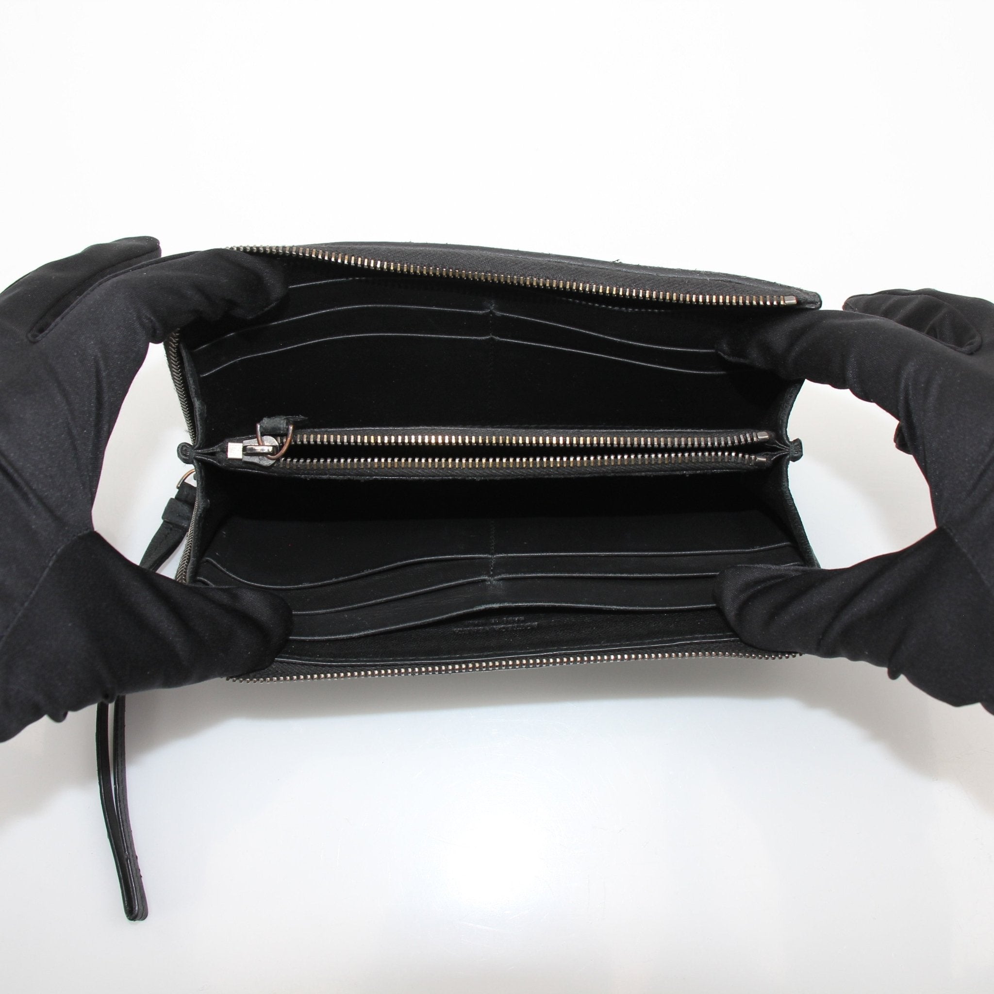 Black Bottega Veneta Nero Intrecciato leather wallet with woven design, featuring a sleek, high-quality texture.