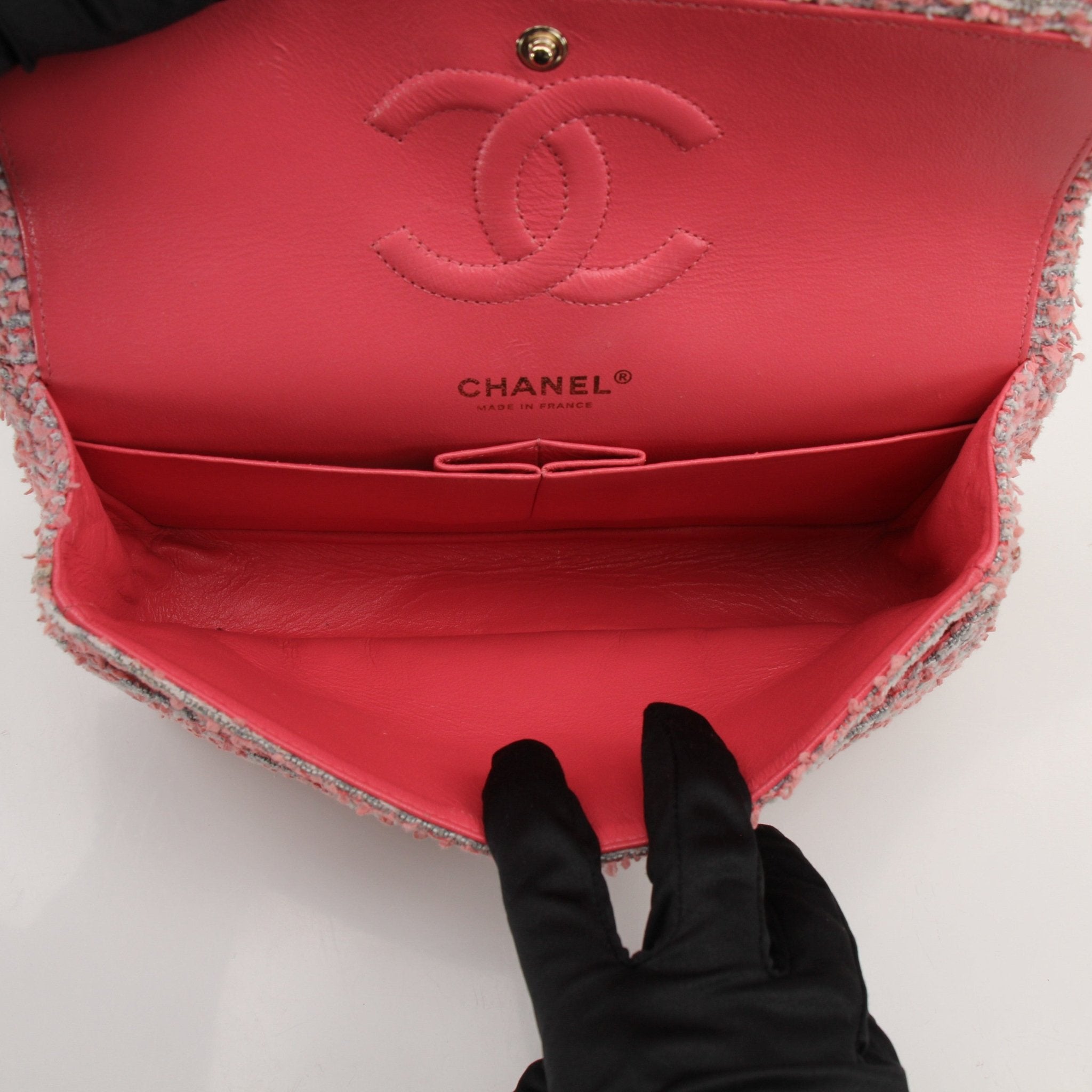 Pink tweed Chanel flap handbag with gold chain strap and classic design, stylish accessory for any outfit.