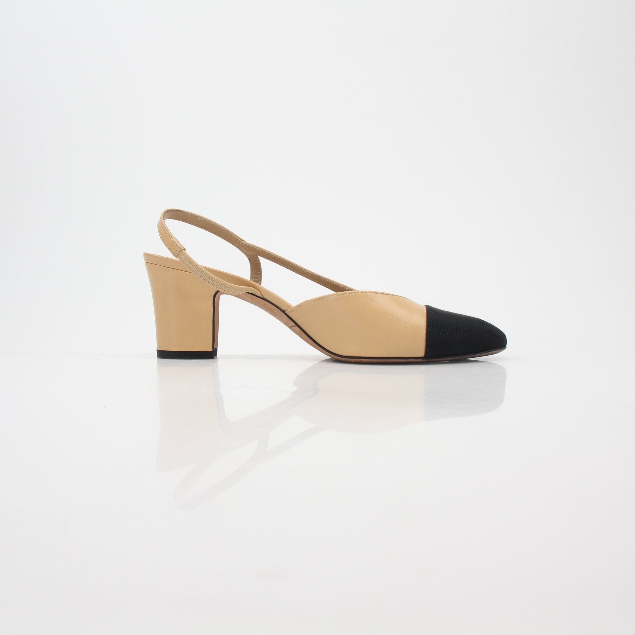 Gold & Beyond beige and black Chanel-inspired slingback pumps with cap-toe design, pointed heels, and classic elegance.