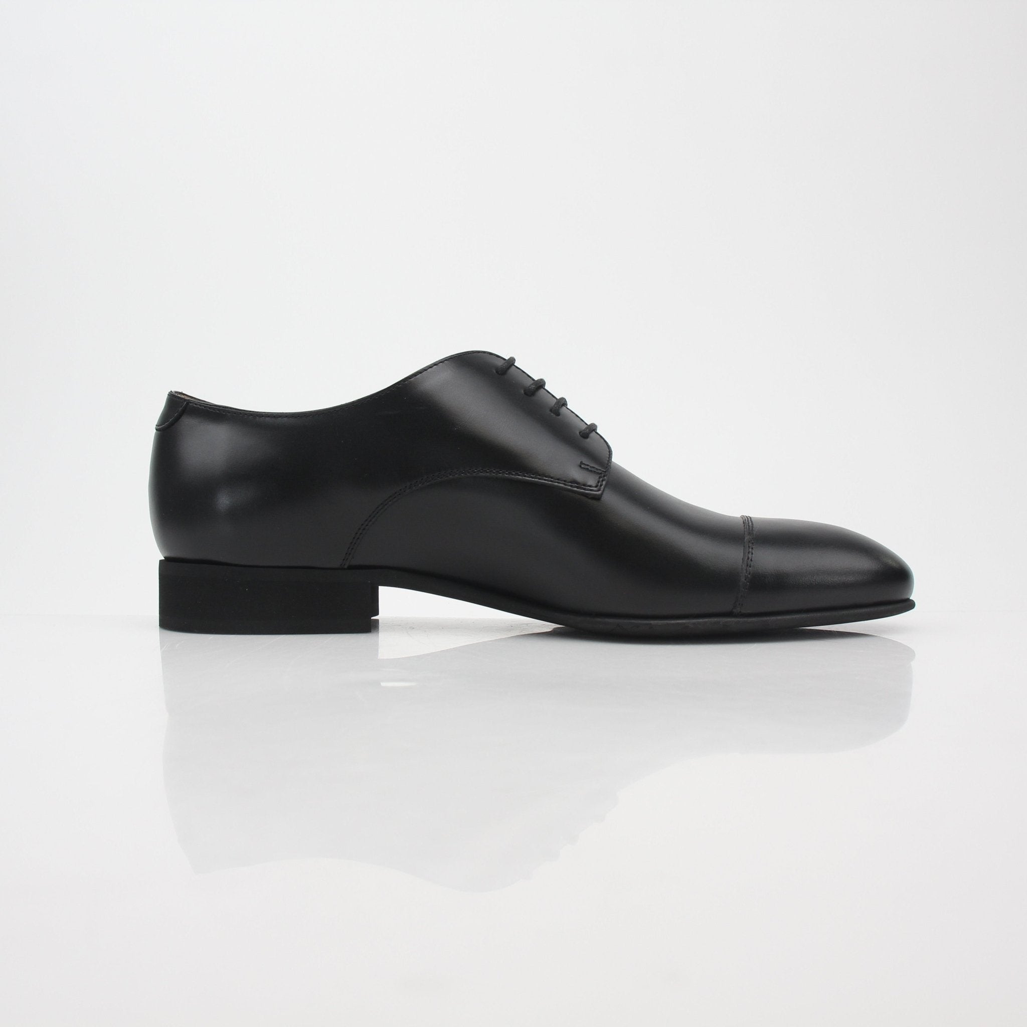 Gold & Beyond Chanel uniform black leather cap-toe derby shoes with sleek design and polished finish.