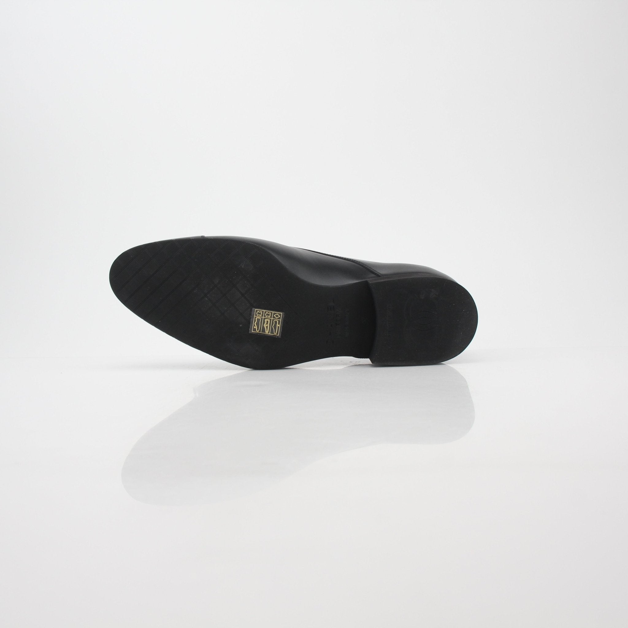 Gold & Beyond Chanel Uniform black leather cap-toe derby shoes with sleek design and polished finish.
