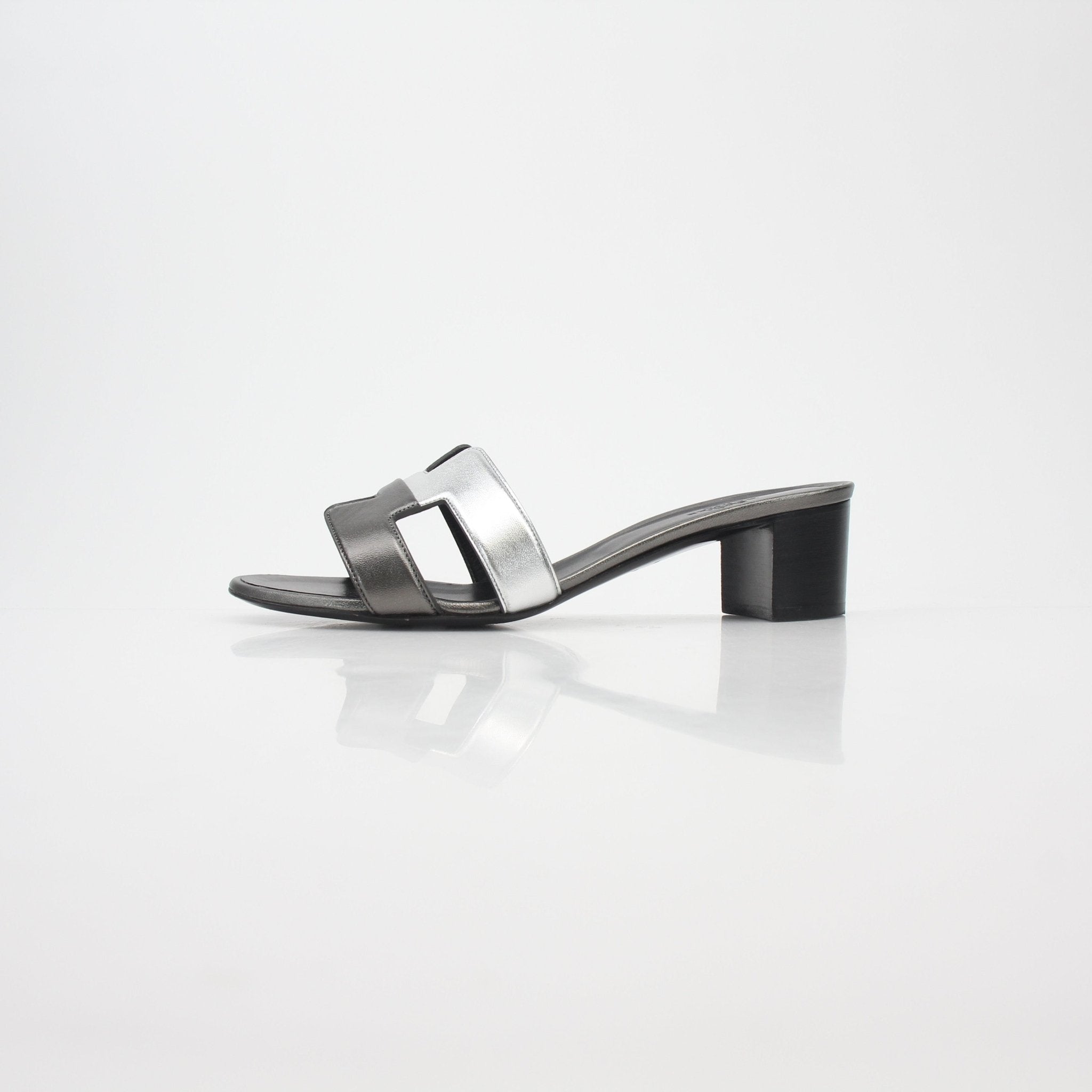 Hermès Metallic Silver Oasis Sandals by Gold & Beyond, showcasing stylish metallic silver shoes with elegant straps and a comfortable sole.