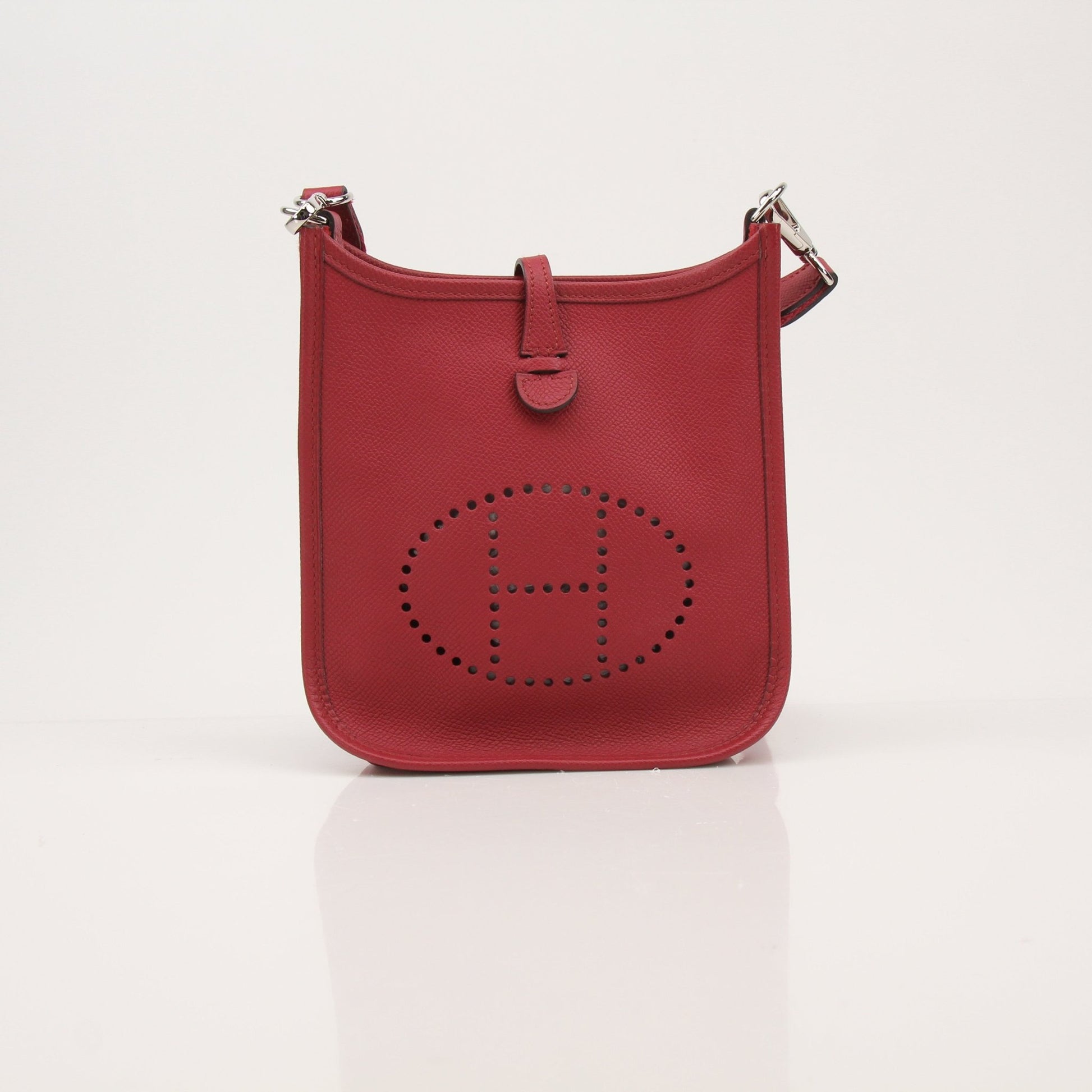 Hermès Evelyne Mini handbag in leather with gold accents, featuring adjustable strap and signature logo detail.