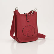 Hermès Evelyne Mini handbag in leather with gold hardware, featuring adjustable strap and signature logo detail.